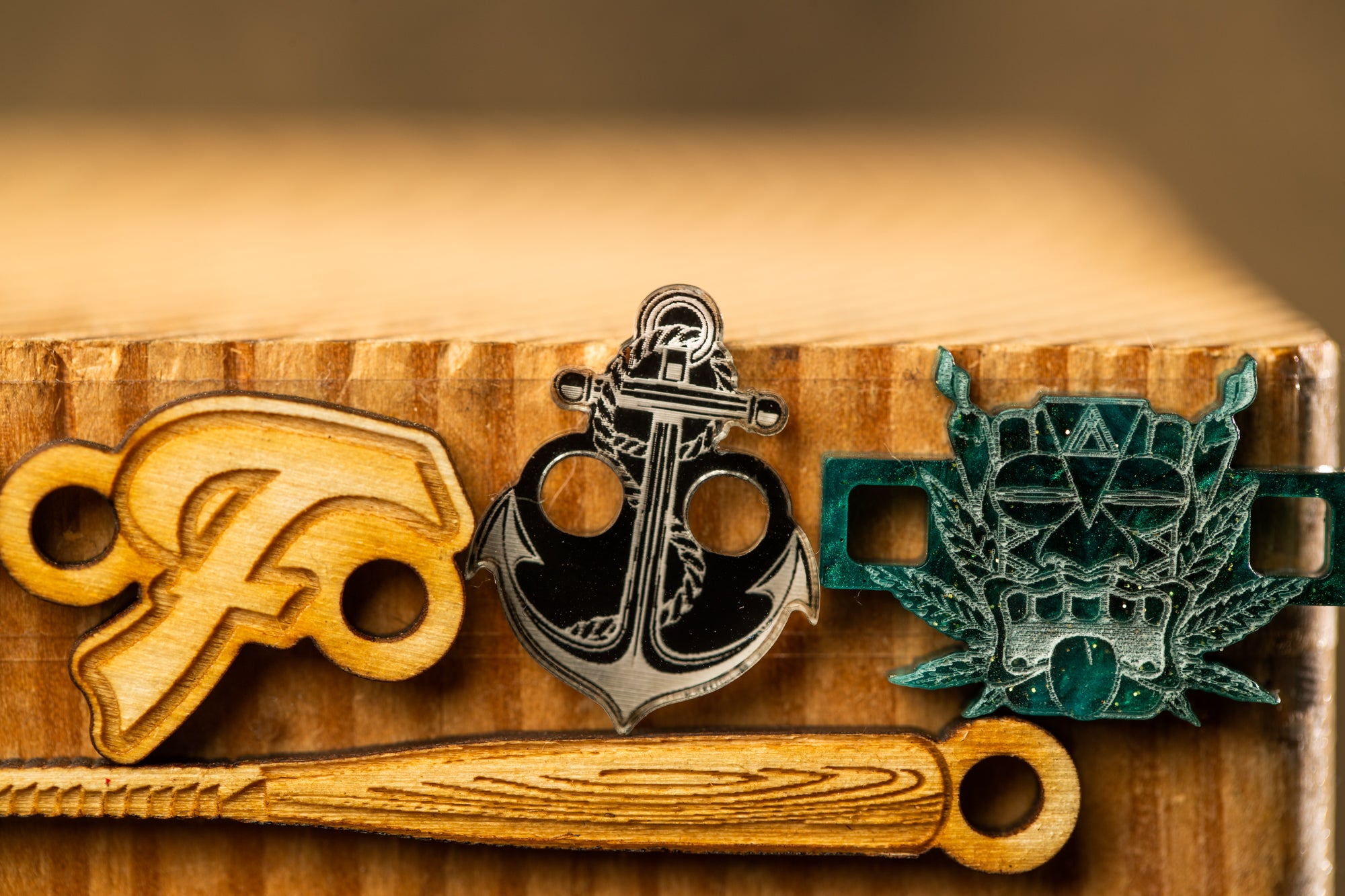 a wooden baseball bat with a logo, a wooden anchor, and a wooden keychain with a key design.