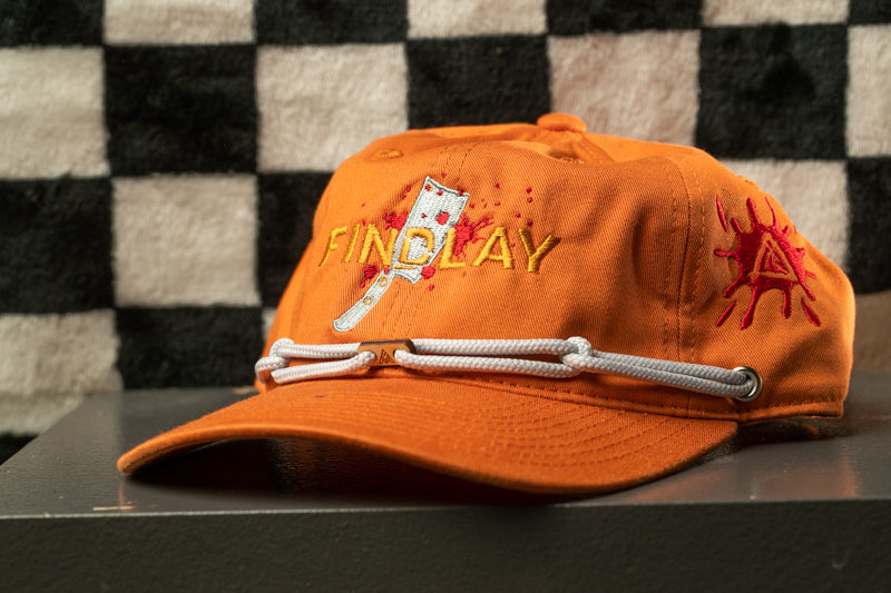 An orange baseball cap with the word "FINDlay" printed on it, along with a graphic of a knife and a red splatter.