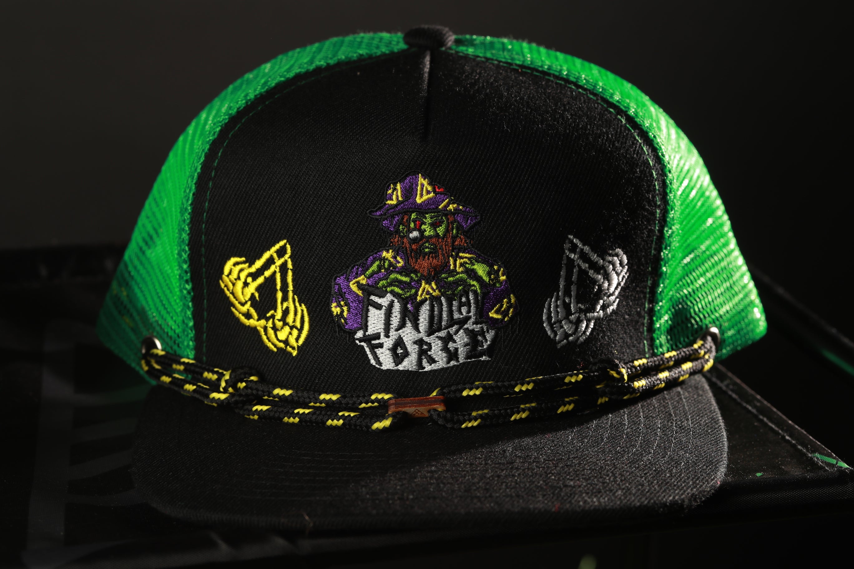 A black and green baseball cap with a colorful embroidered design on the front.