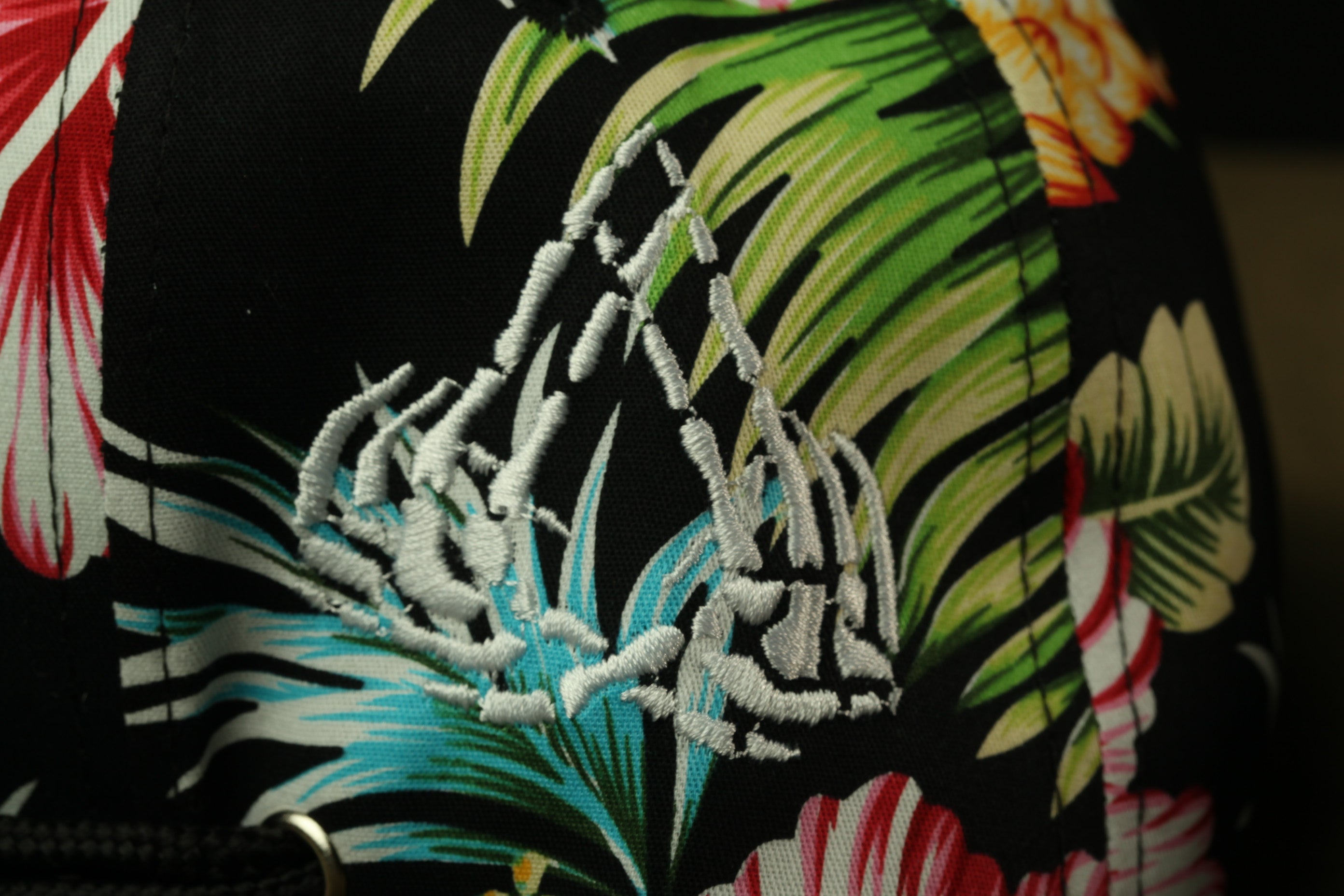 a close-up view of a colorful, floral-patterned fabric with a black background.