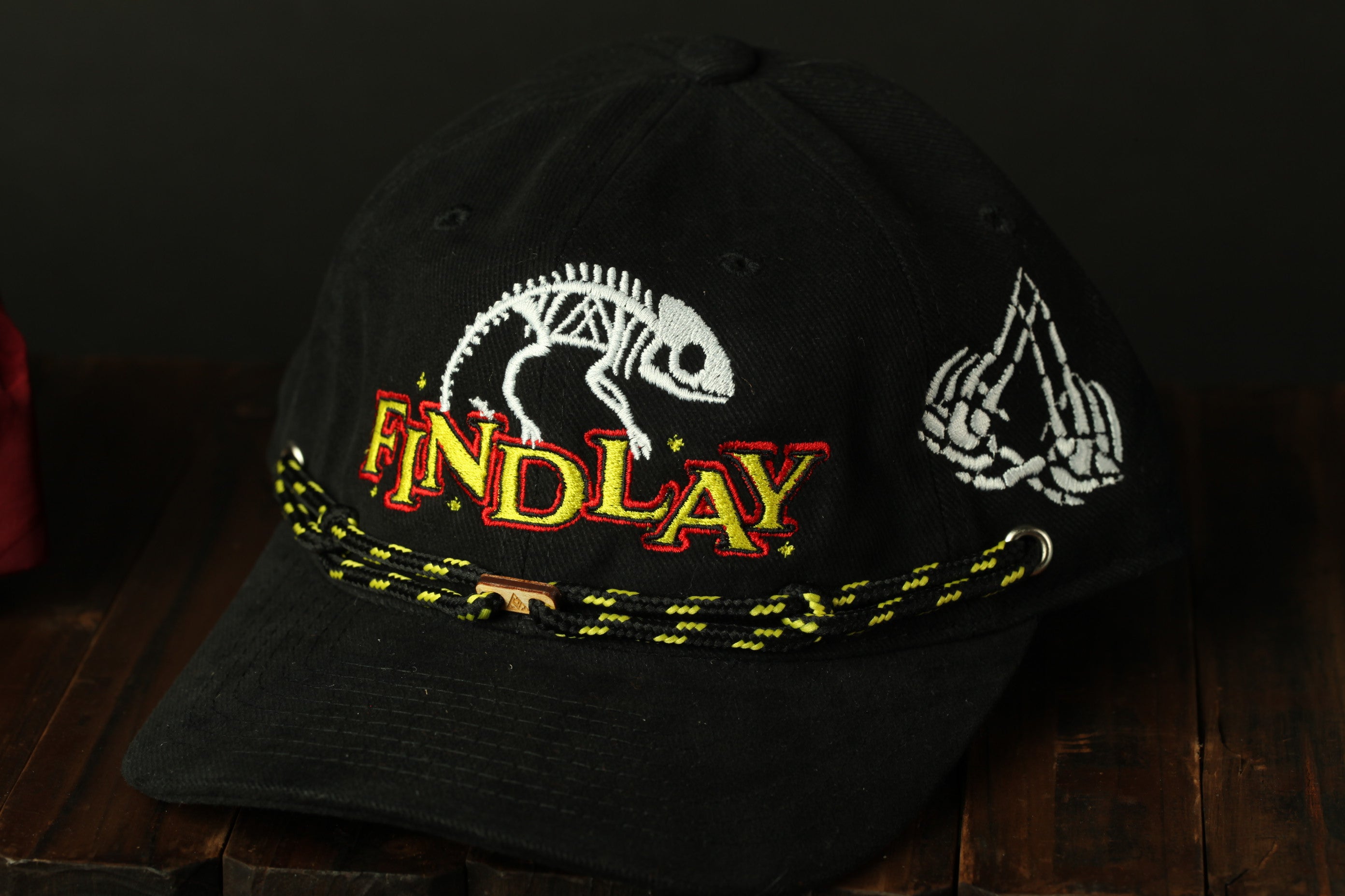 A black baseball cap with a skeleton design and the word "FINDlay" printed on it.