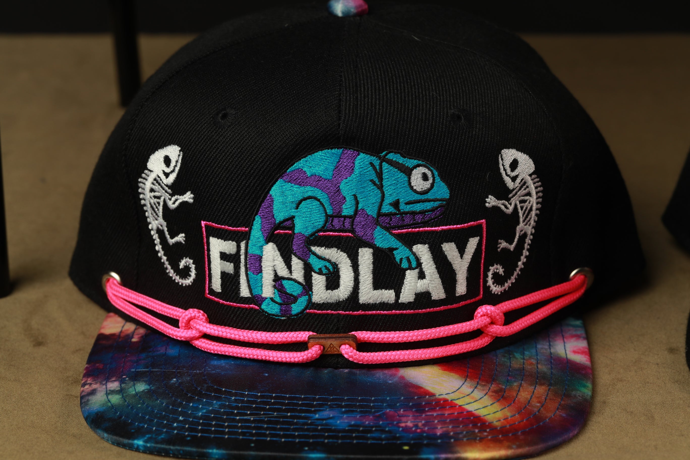 A black baseball cap with a colorful design and the word "FINDlay" printed on it.