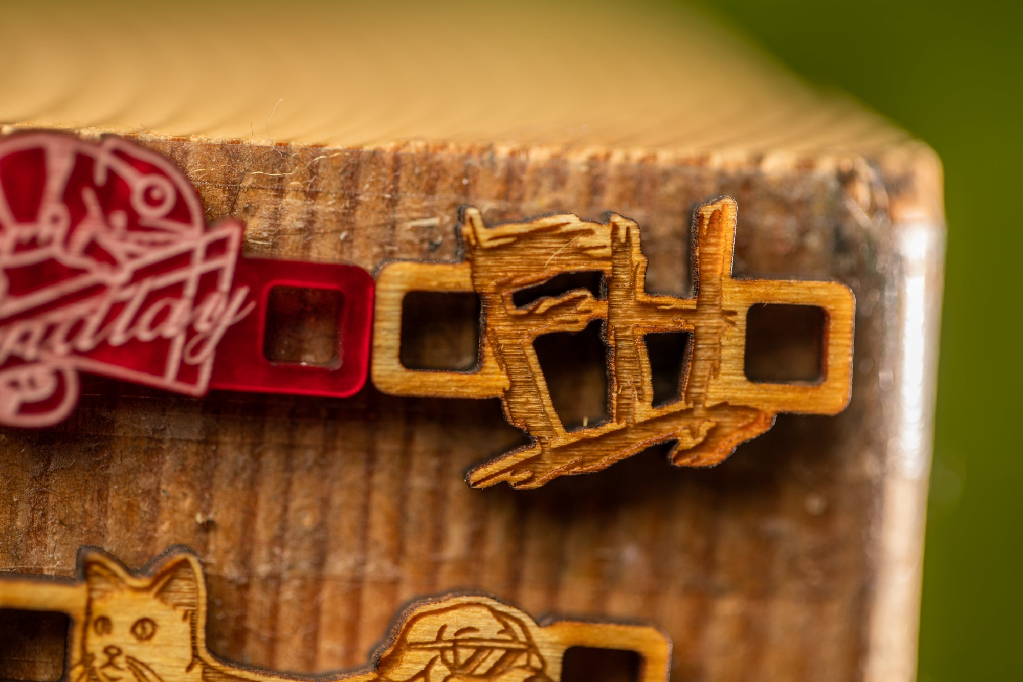 a close-up view of a wooden surface with several wooden objects, including a wooden piece with a carved design and a red plastic object.