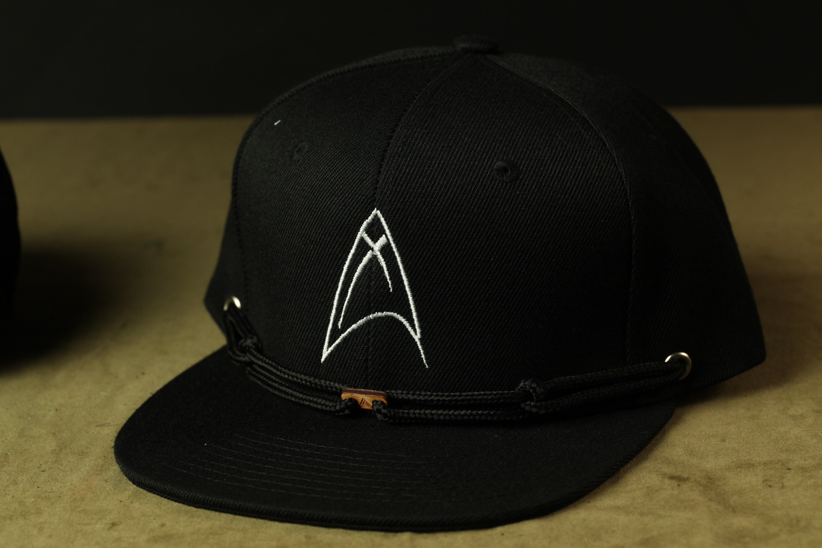 A black baseball cap with a white logo on the front.