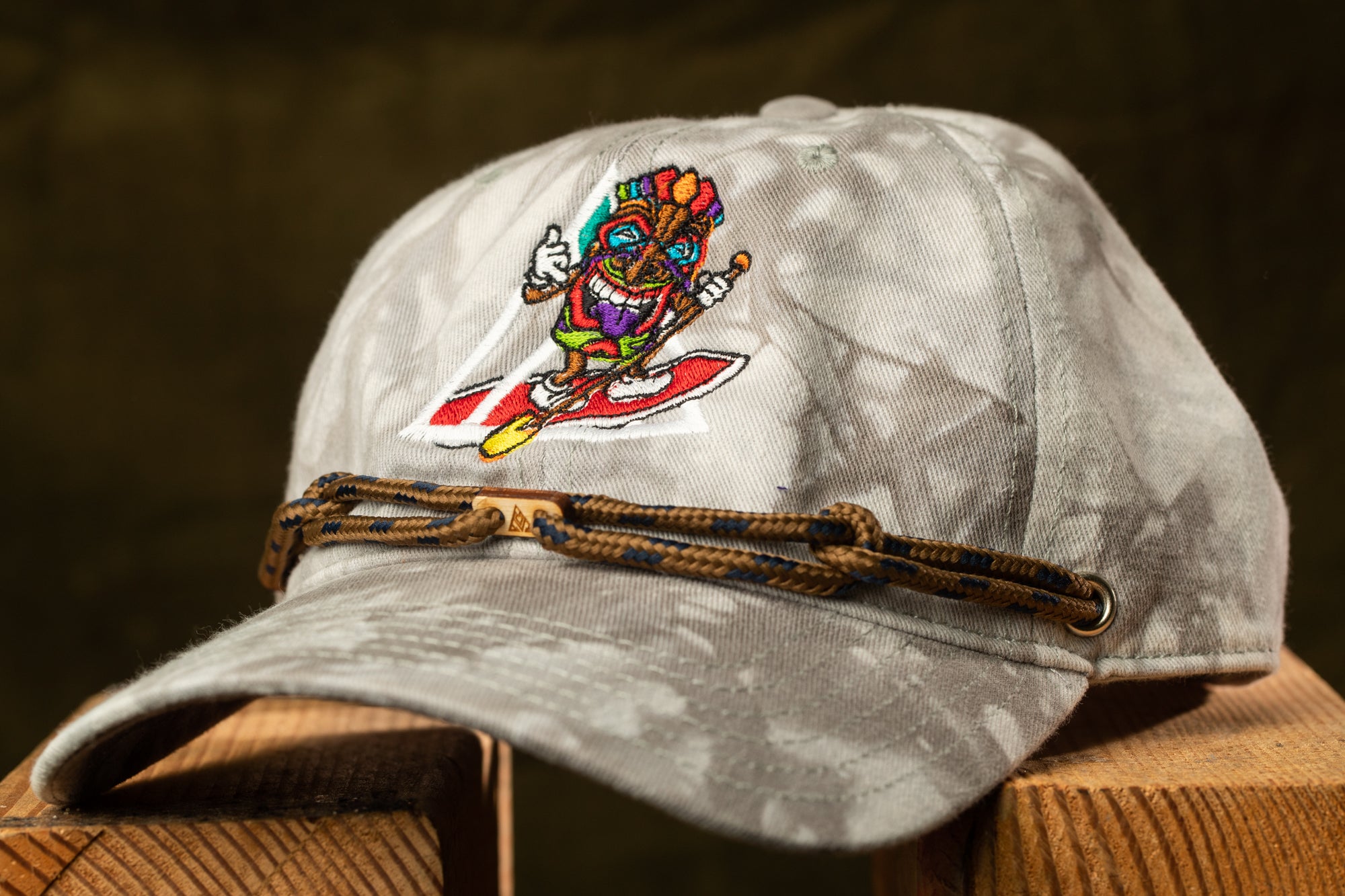 A gray baseball cap with a colorful, cartoonish design on the front.