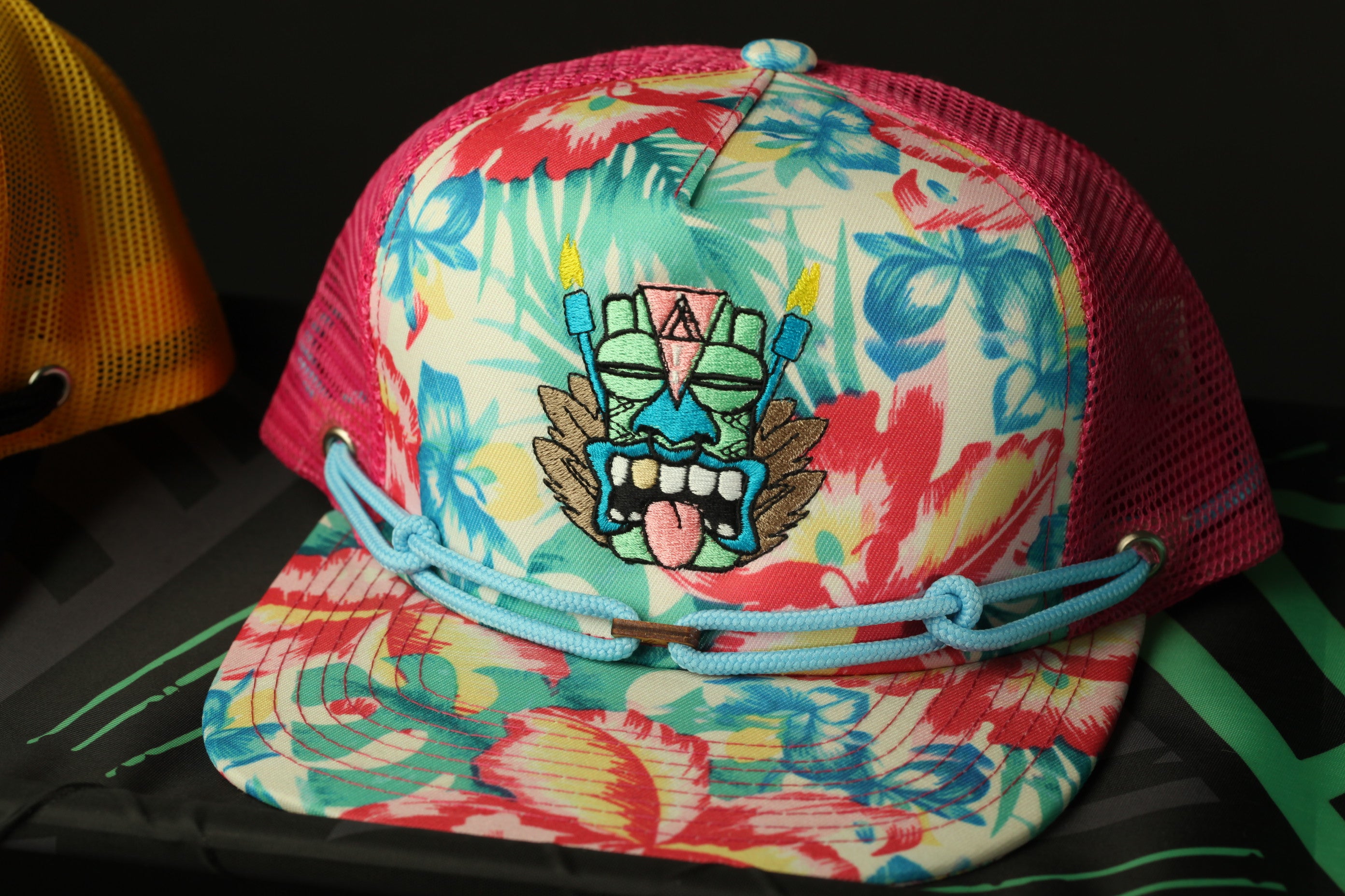 A colorful floral-patterned baseball cap with a graphic design on the front.