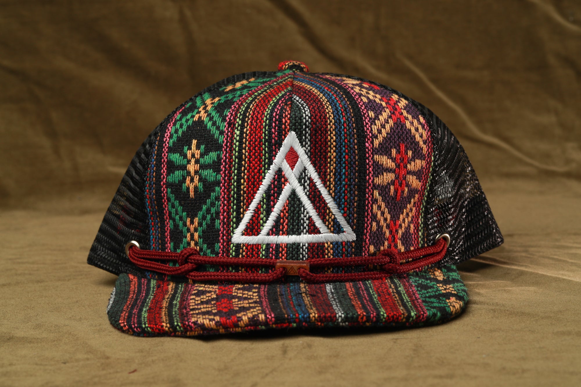 A colorful, patterned baseball cap with a white triangle logo on the front.