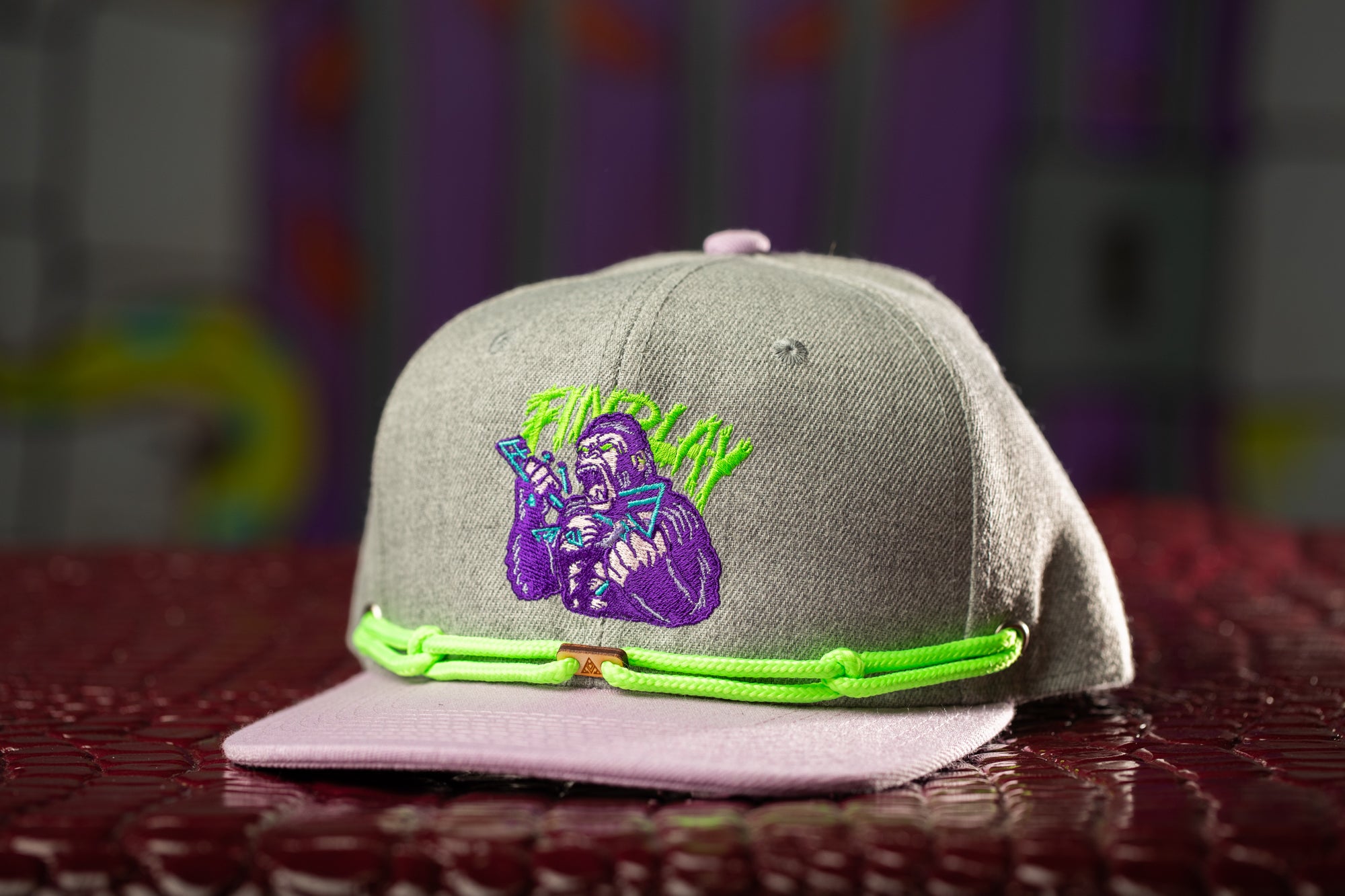 a gray and pink hat with a picture of a man on it
