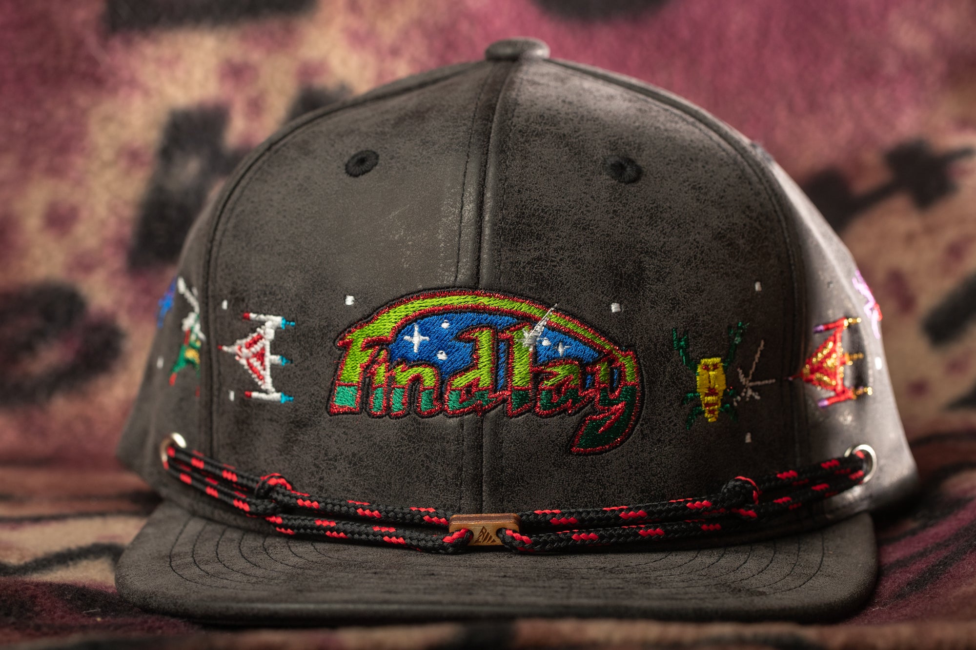 A black baseball cap with colorful embroidered designs and the word "Findlay" printed on it.