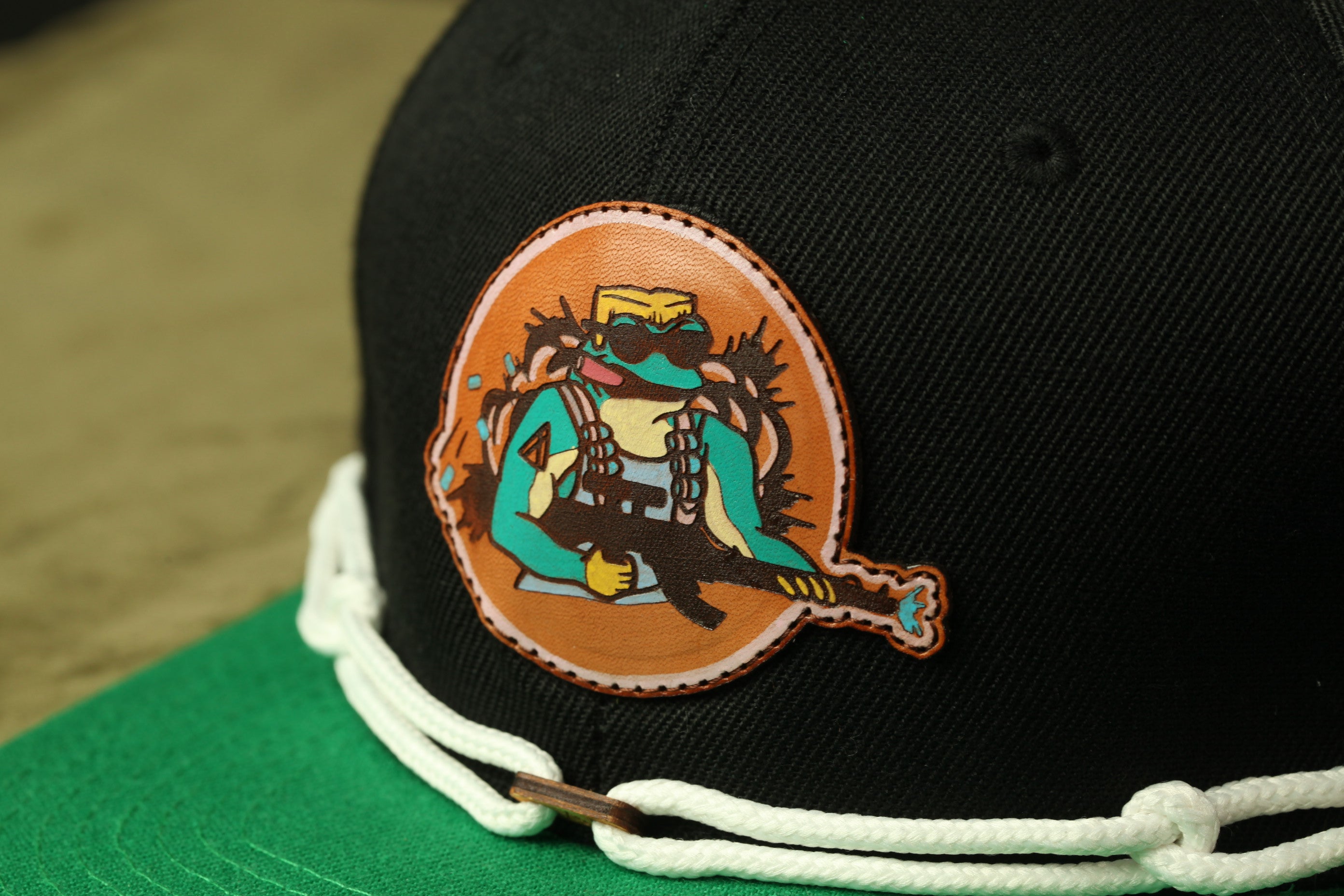 A close-up view of a black baseball cap with a colorful patch featuring a cartoon character on it.