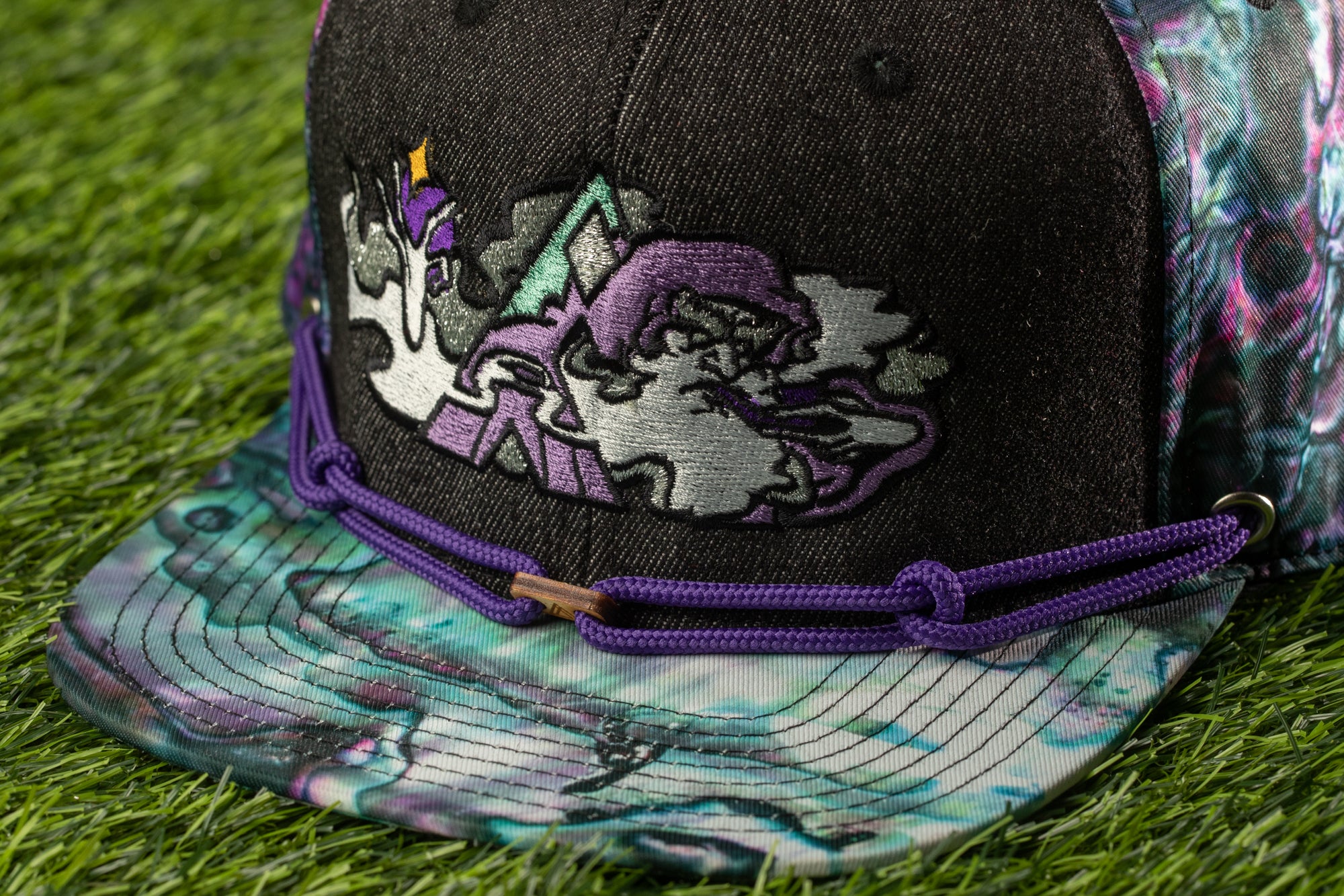 A close-up view of a colorful baseball cap with a unique embroidered design on the front.