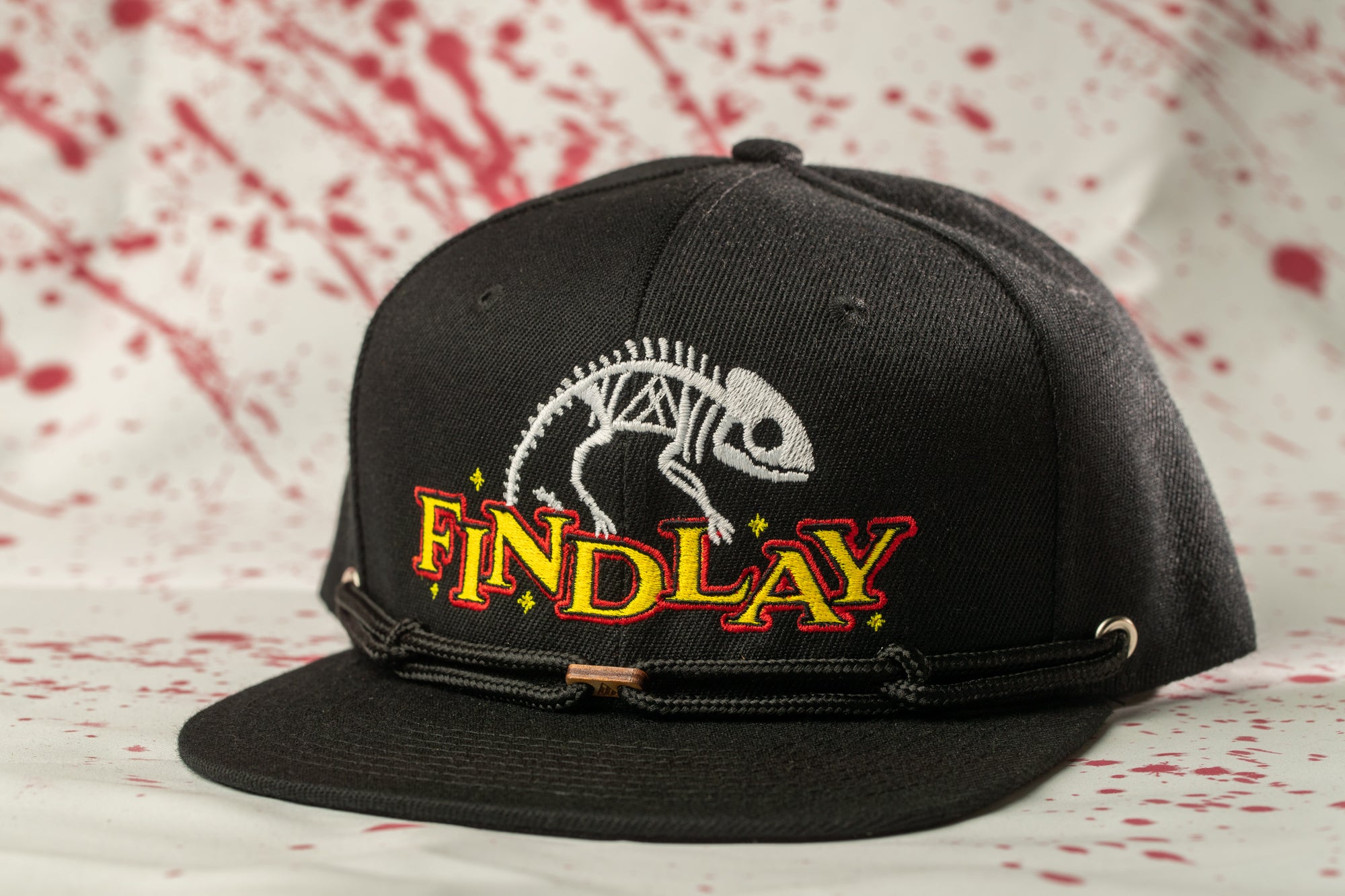 A black baseball cap with a skeleton design and the word "FINDlay" printed on it.