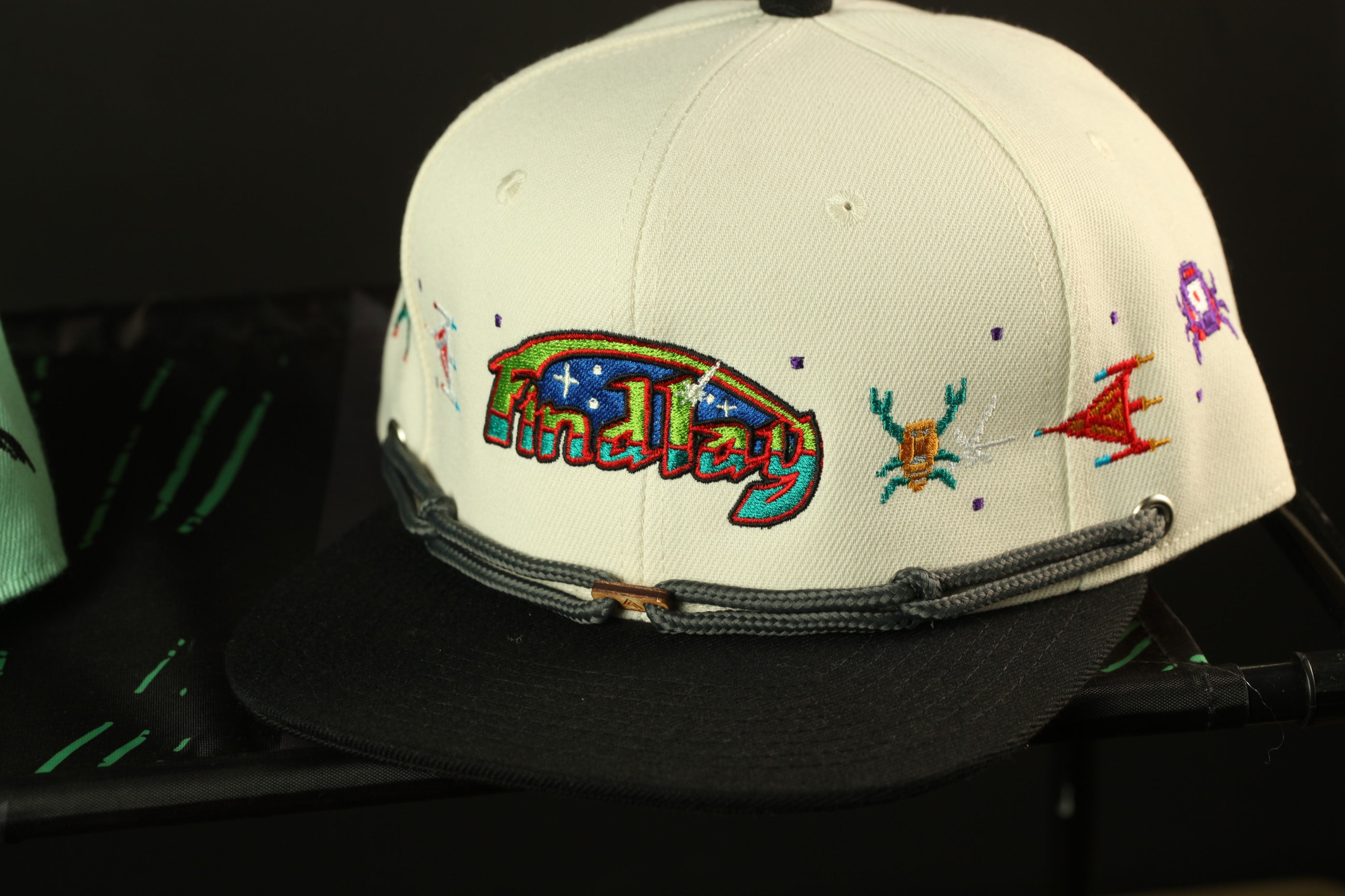 A white baseball cap with colorful embroidered designs on the front.