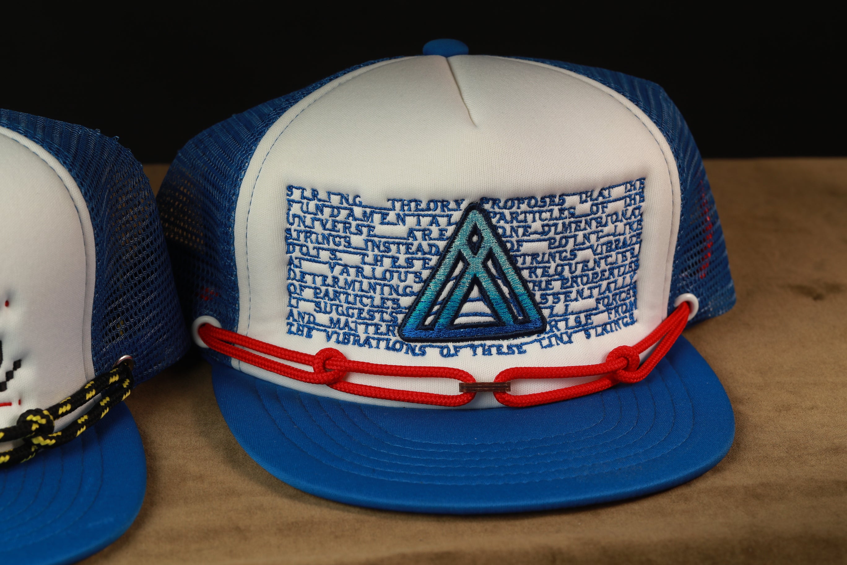 A blue and white baseball cap with a triangular logo on the front.