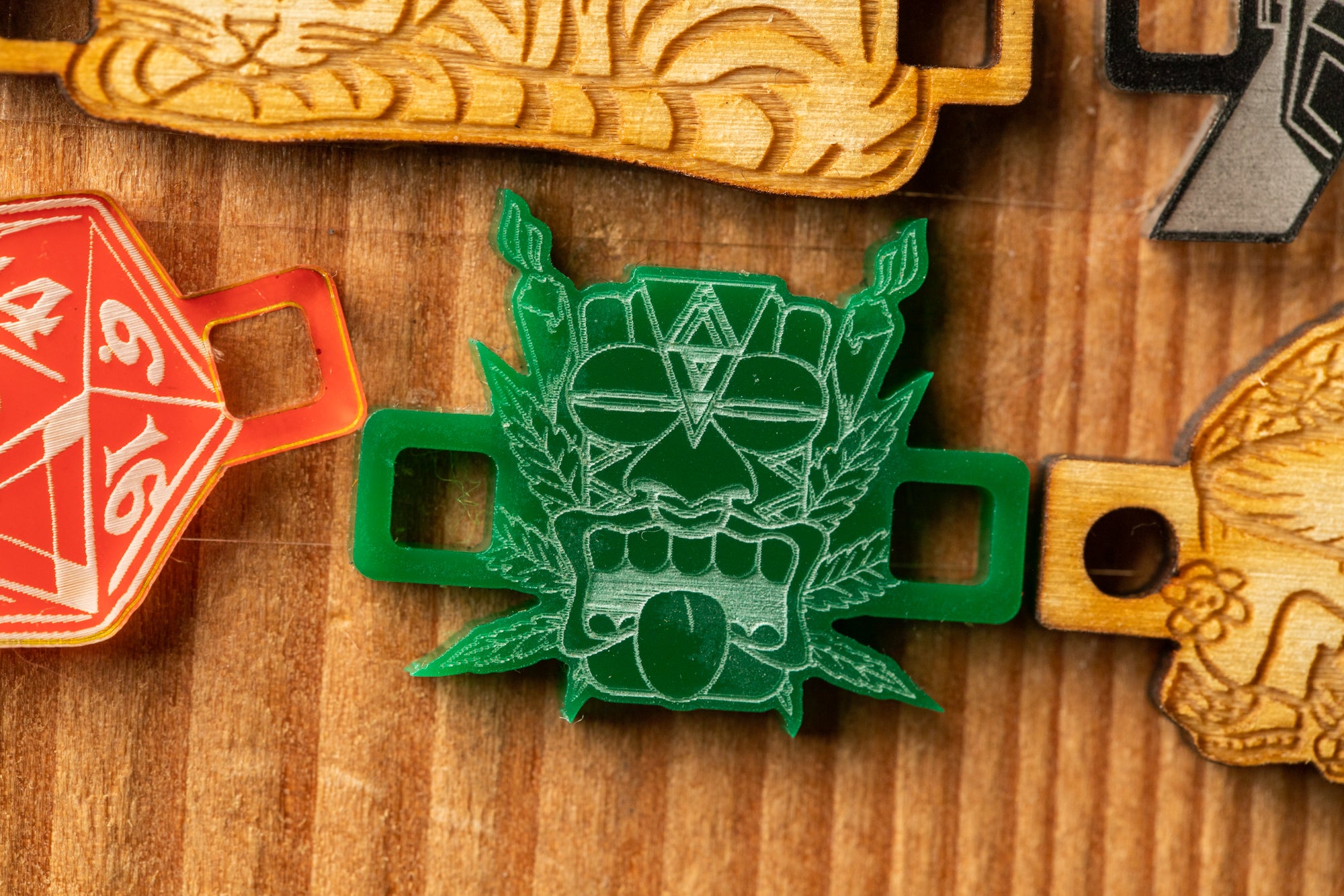 a green plastic object with a skull-like design, surrounded by other wooden objects with various shapes and patterns.