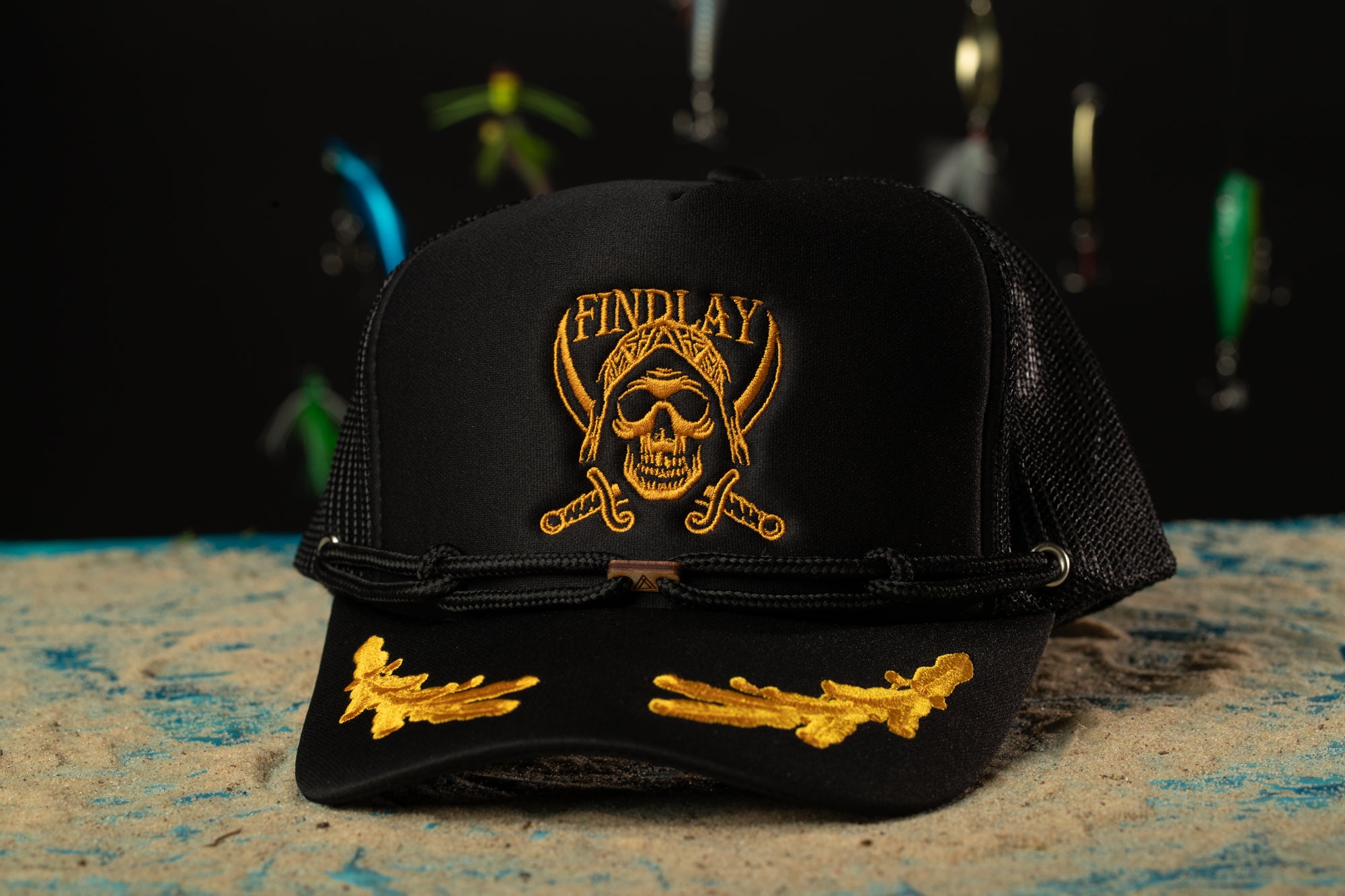 a black and gold hat with a skull and crossed swords on it
