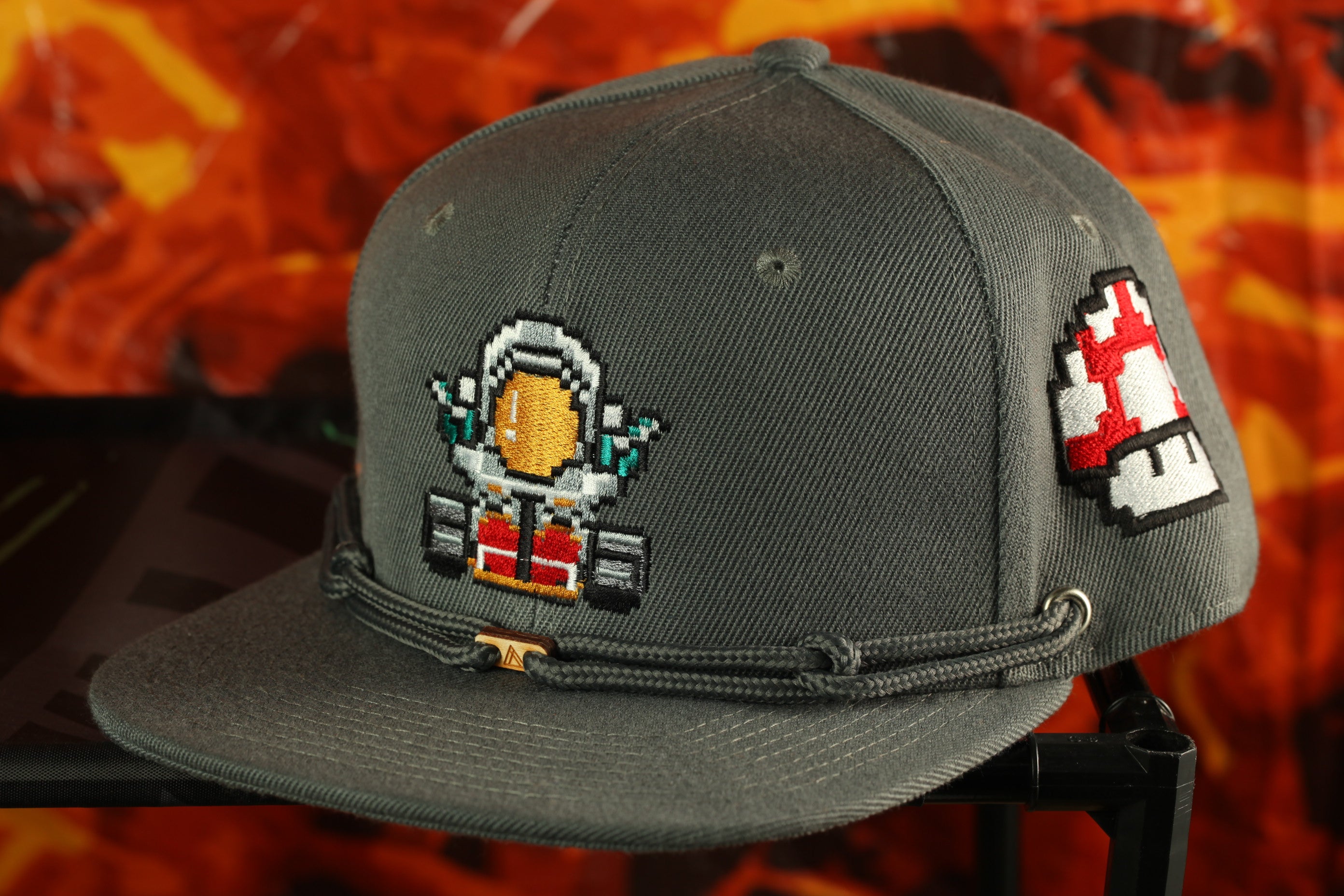 A gray baseball cap with a pixelated character design on the front.