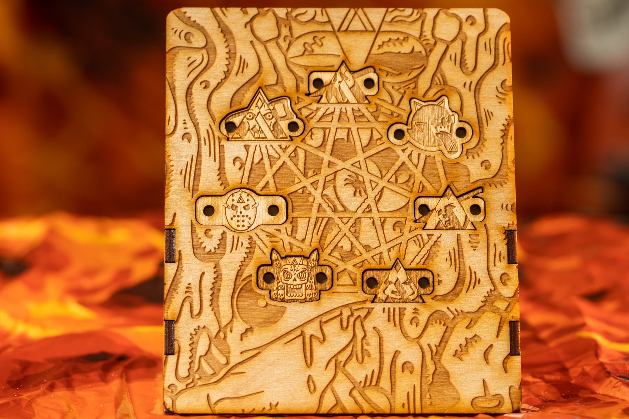 a wooden box with intricate engravings, including various symbols and designs, set against a blurred orange background.