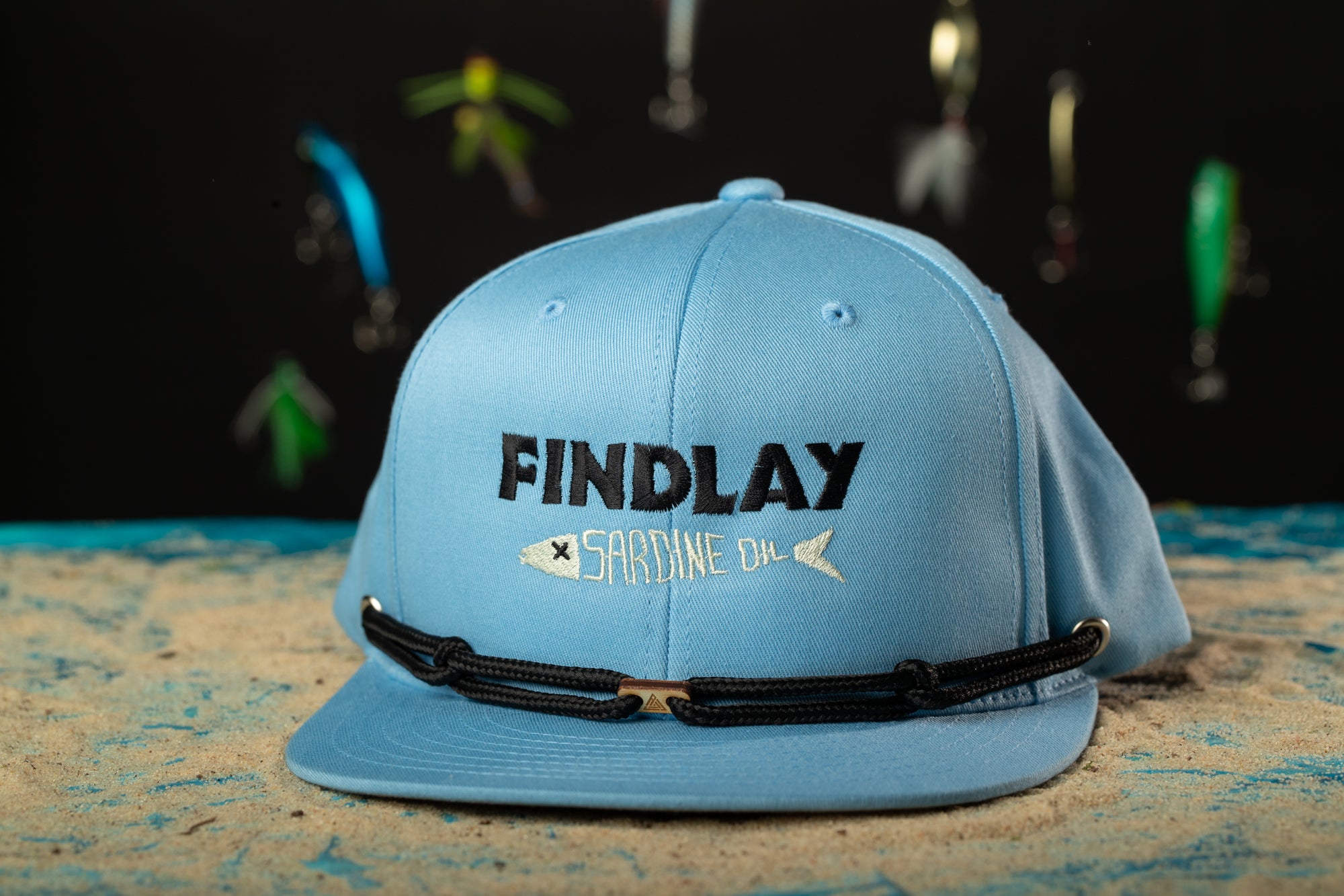 a blue hat with fishing hooks hanging from it