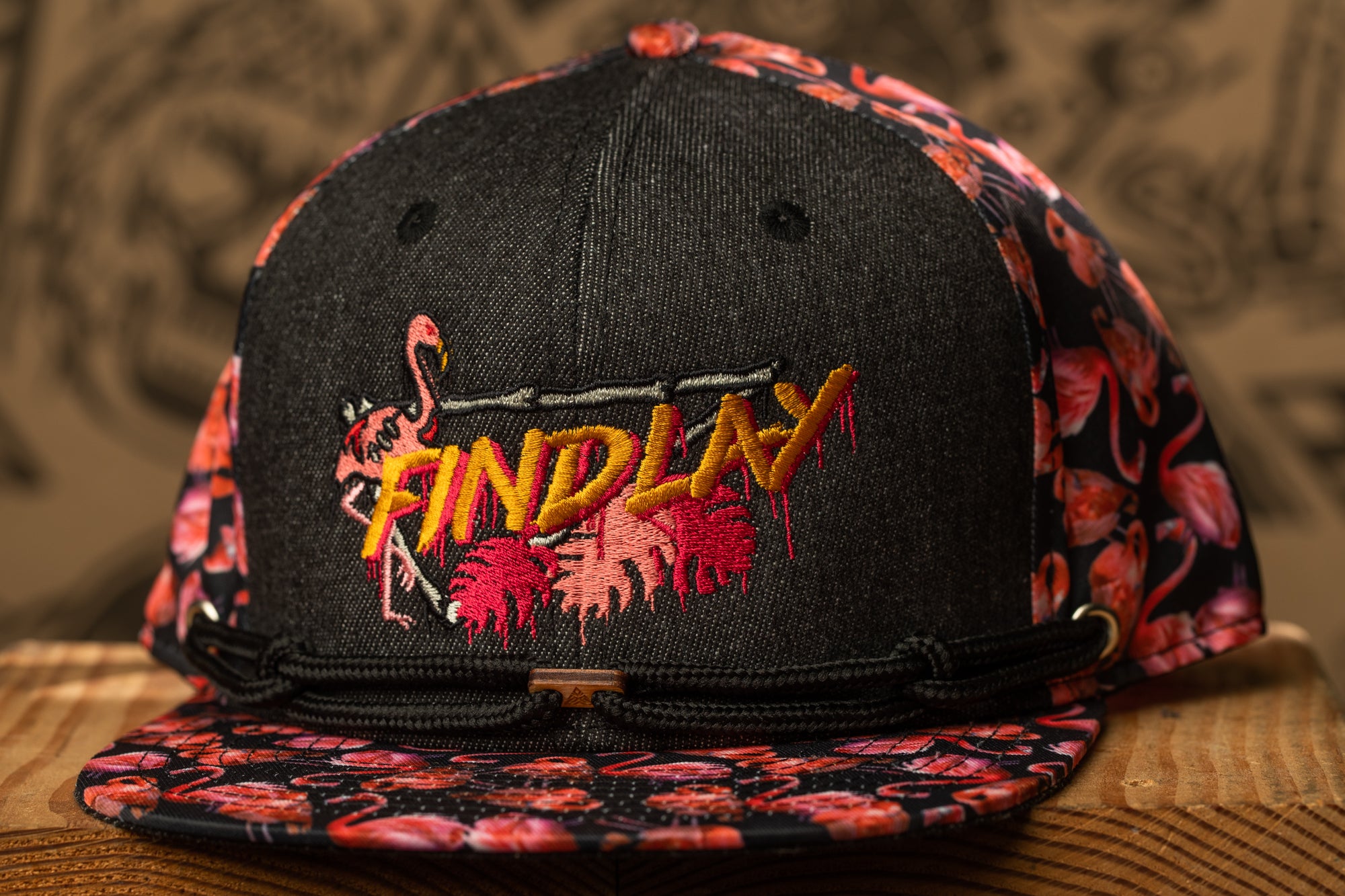 A black baseball cap with a floral pattern and the word "FINDlay" embroidered on it.