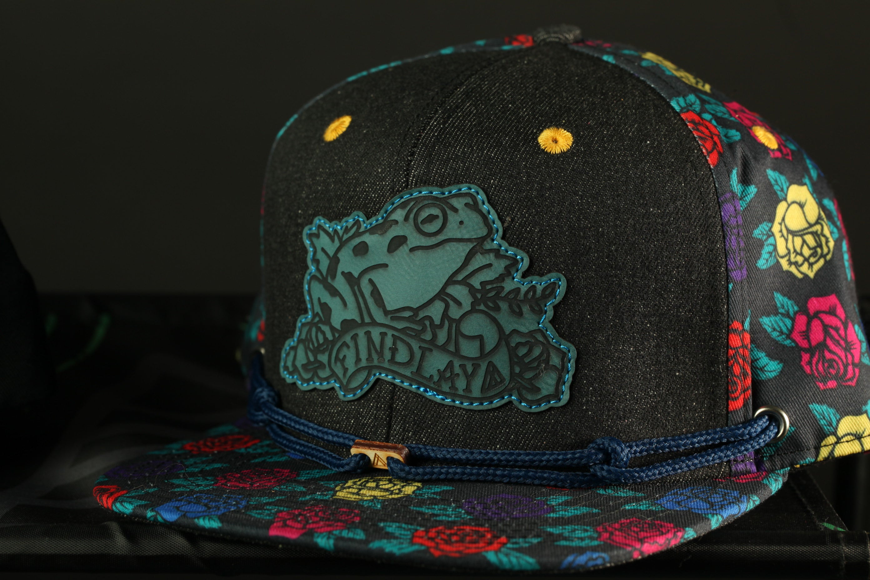 A colorful baseball cap with a frog design on the front.