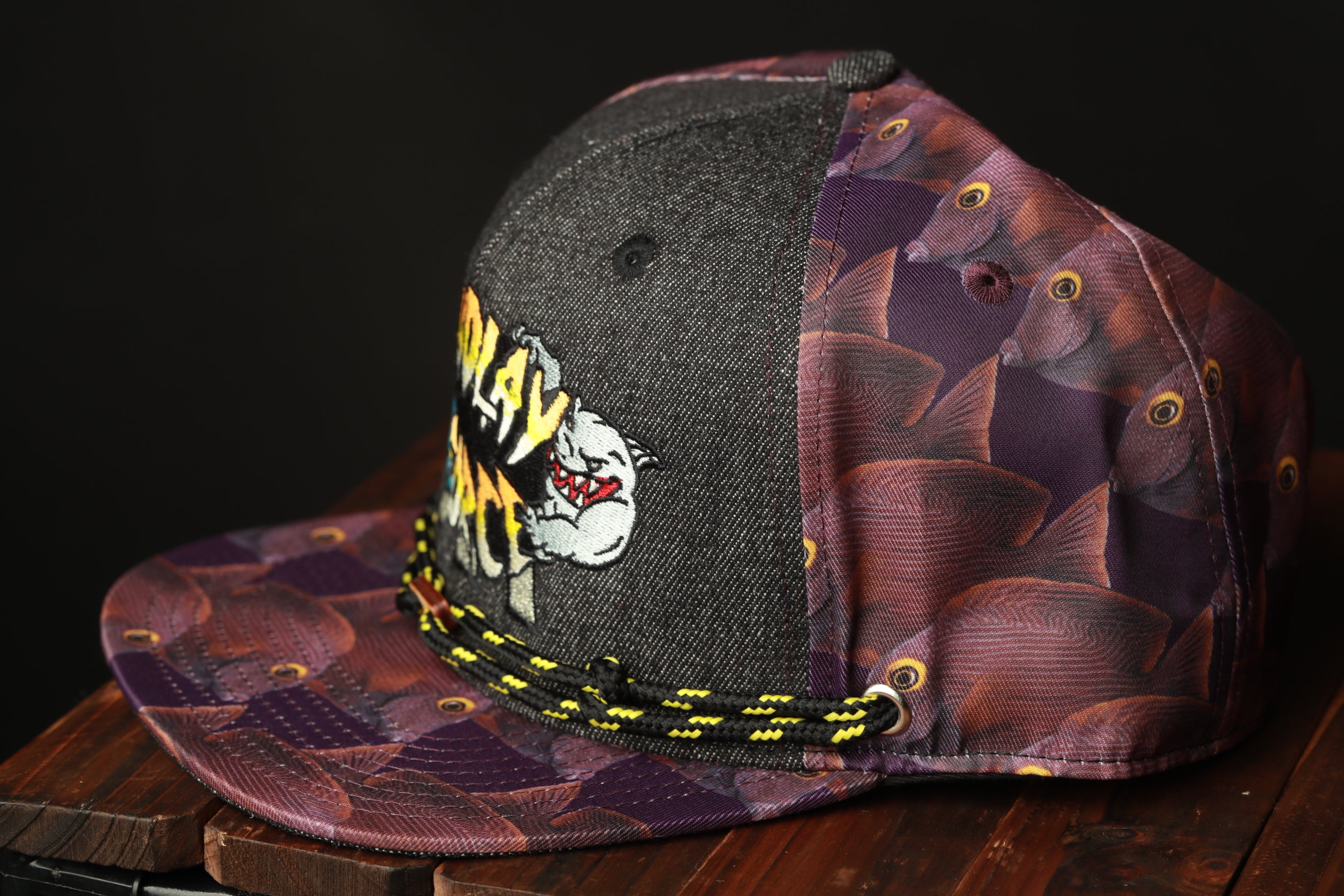 A colorful baseball cap with a fish print pattern and a black brim.