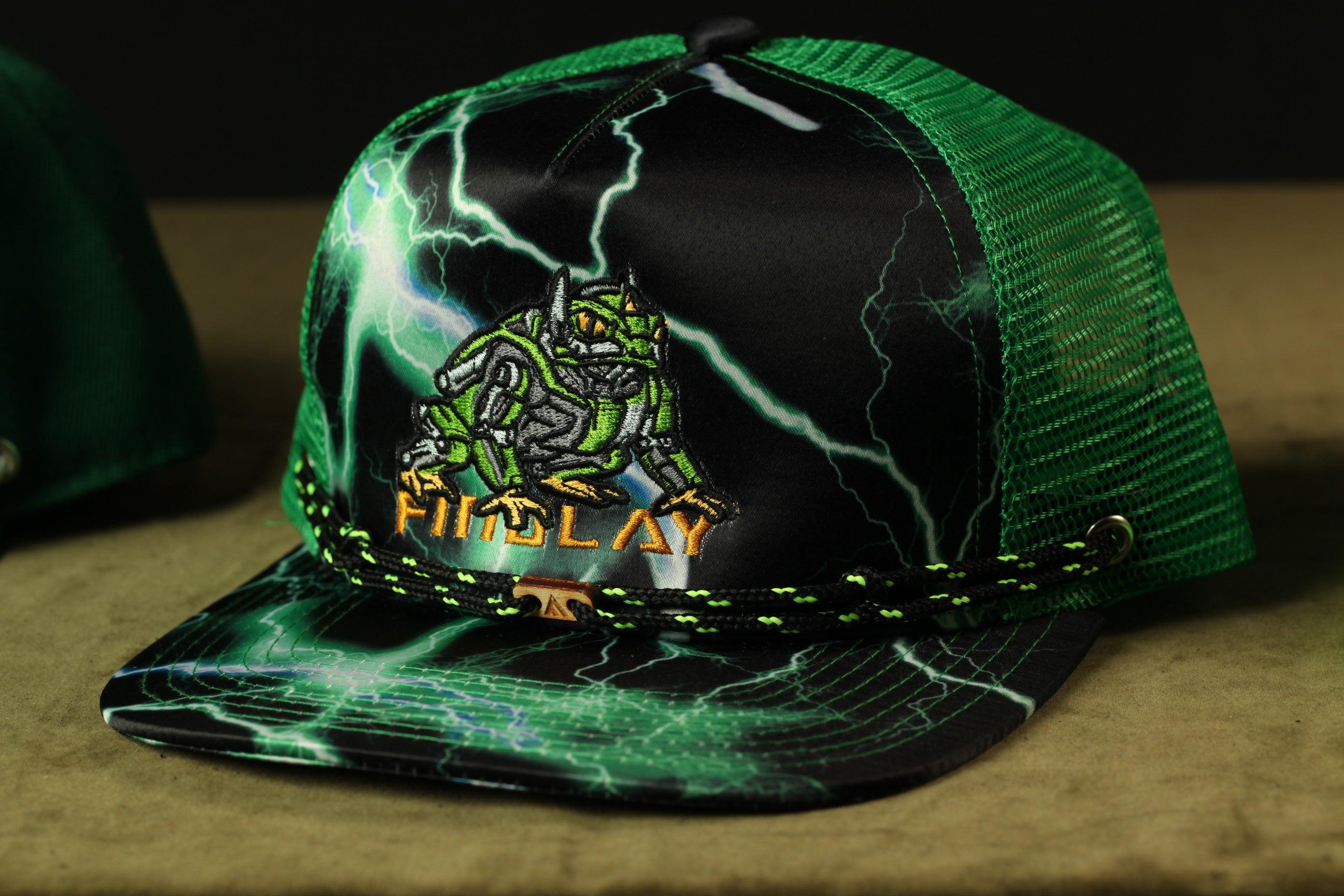 A green and black baseball cap with a lightning bolt design and the word "FIDELAT" printed on it.