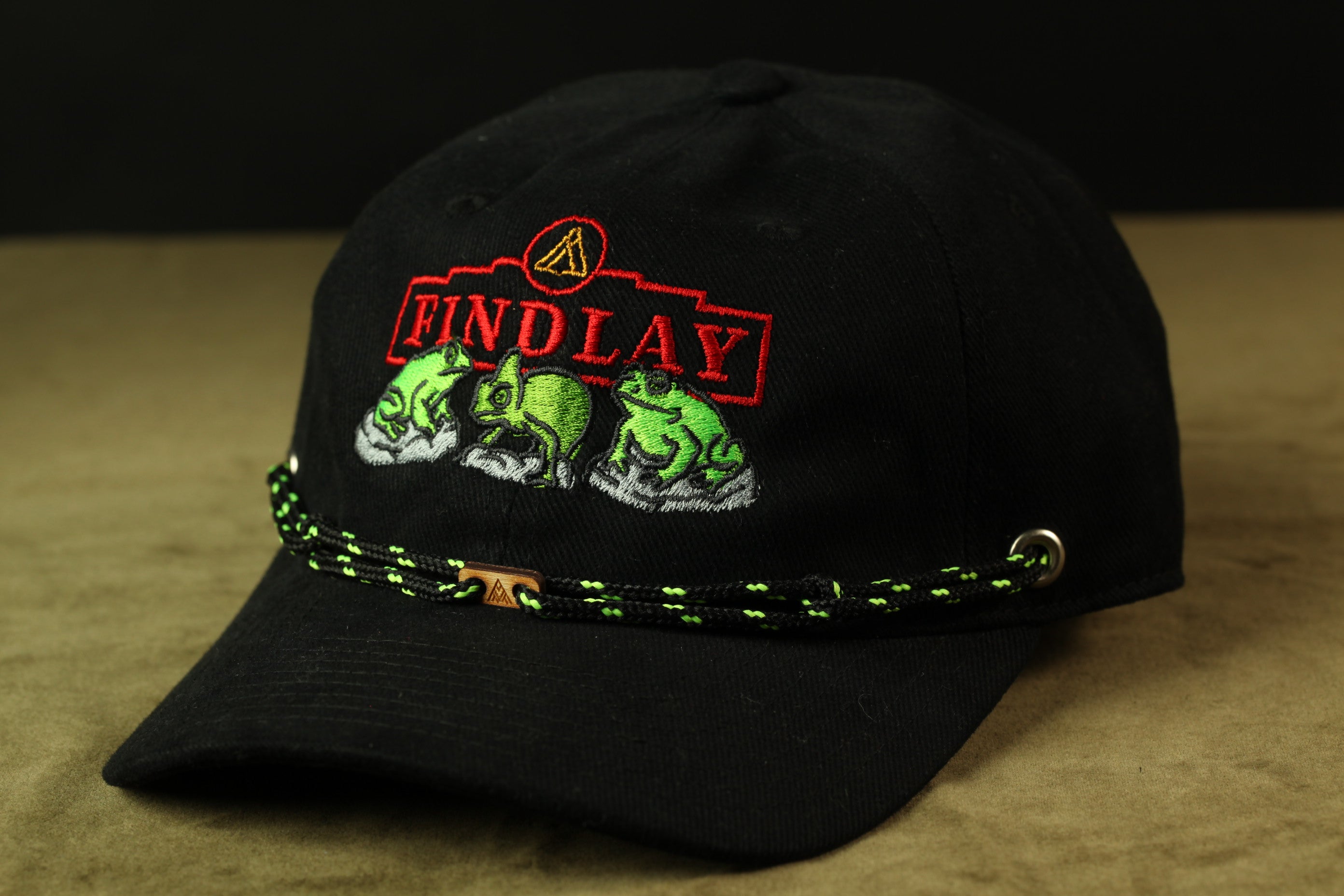 A black baseball cap with a red and green embroidered logo on the front.