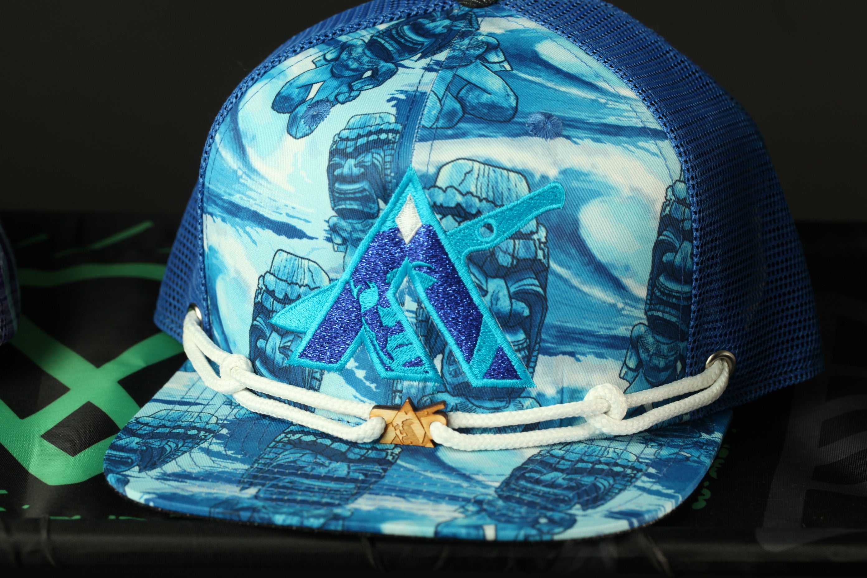 A blue and white baseball cap with a pattern of blue and white cartoon characters, including a large blue triangle with a gold star in the center.