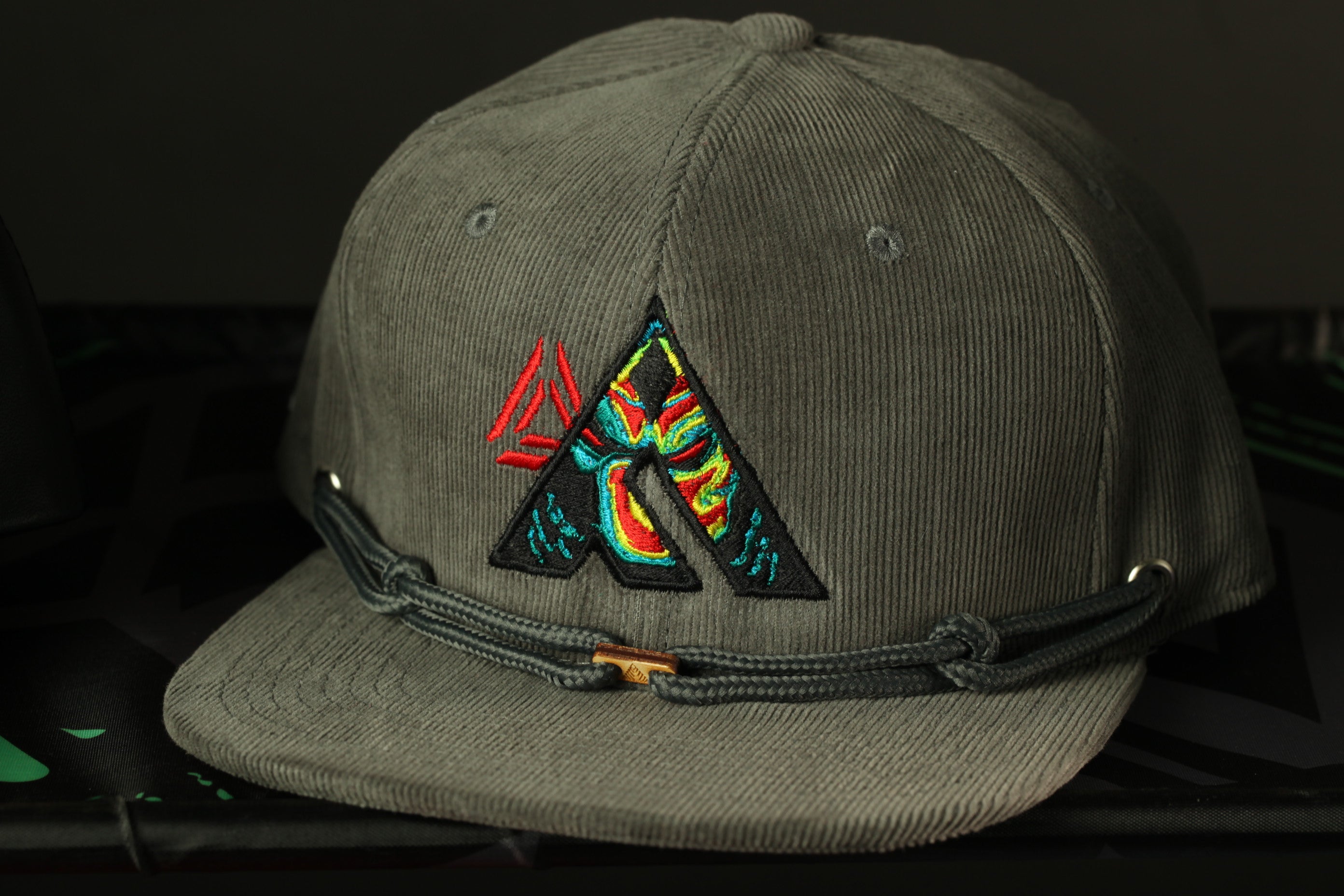 A gray baseball cap with a colorful, abstract design on the front.