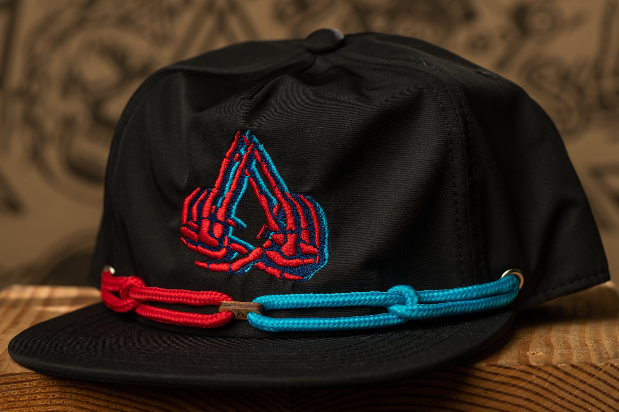 A black baseball cap with a red and blue embroidered logo on the front.