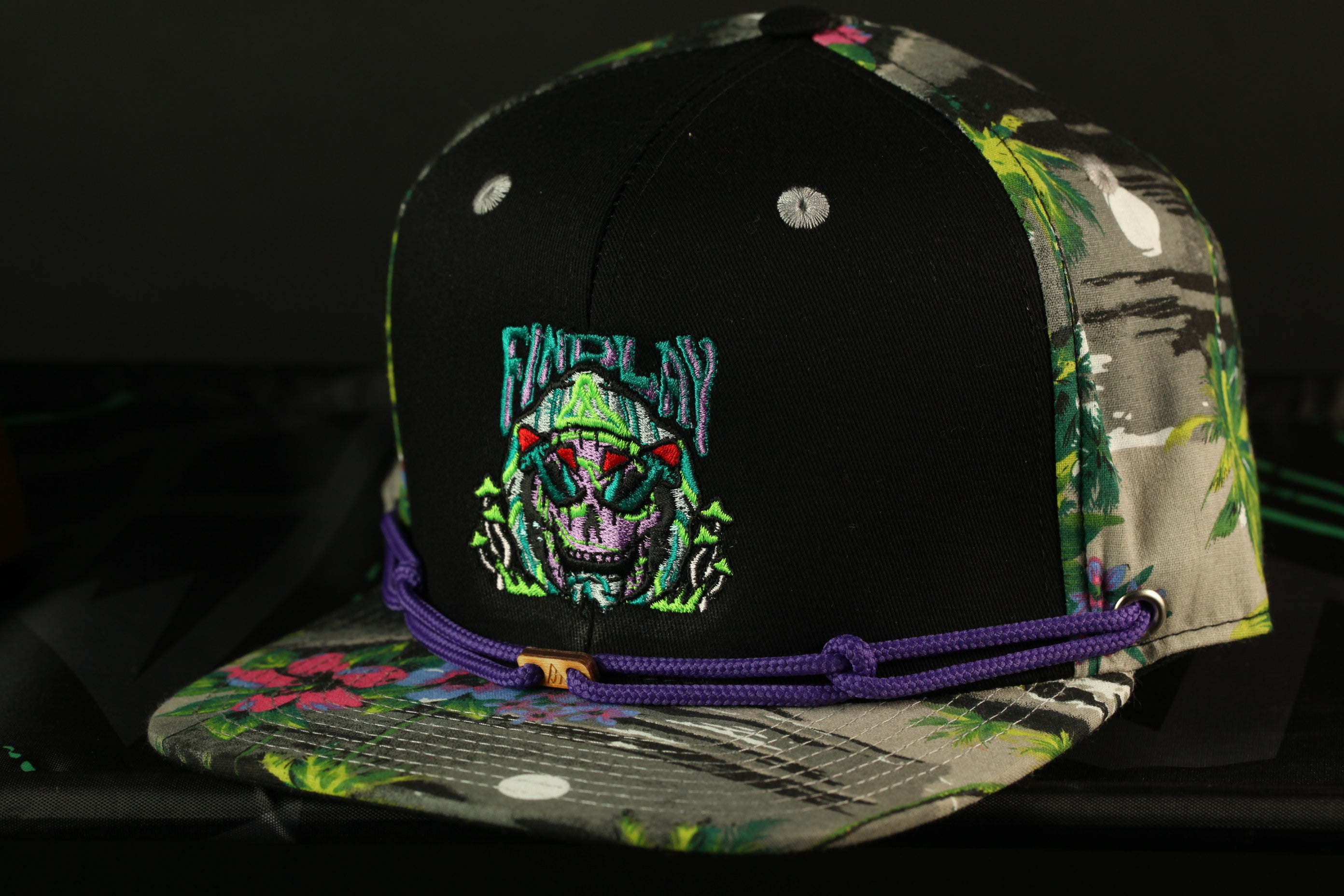 A colorful baseball cap with a skull design and a purple string around the brim.