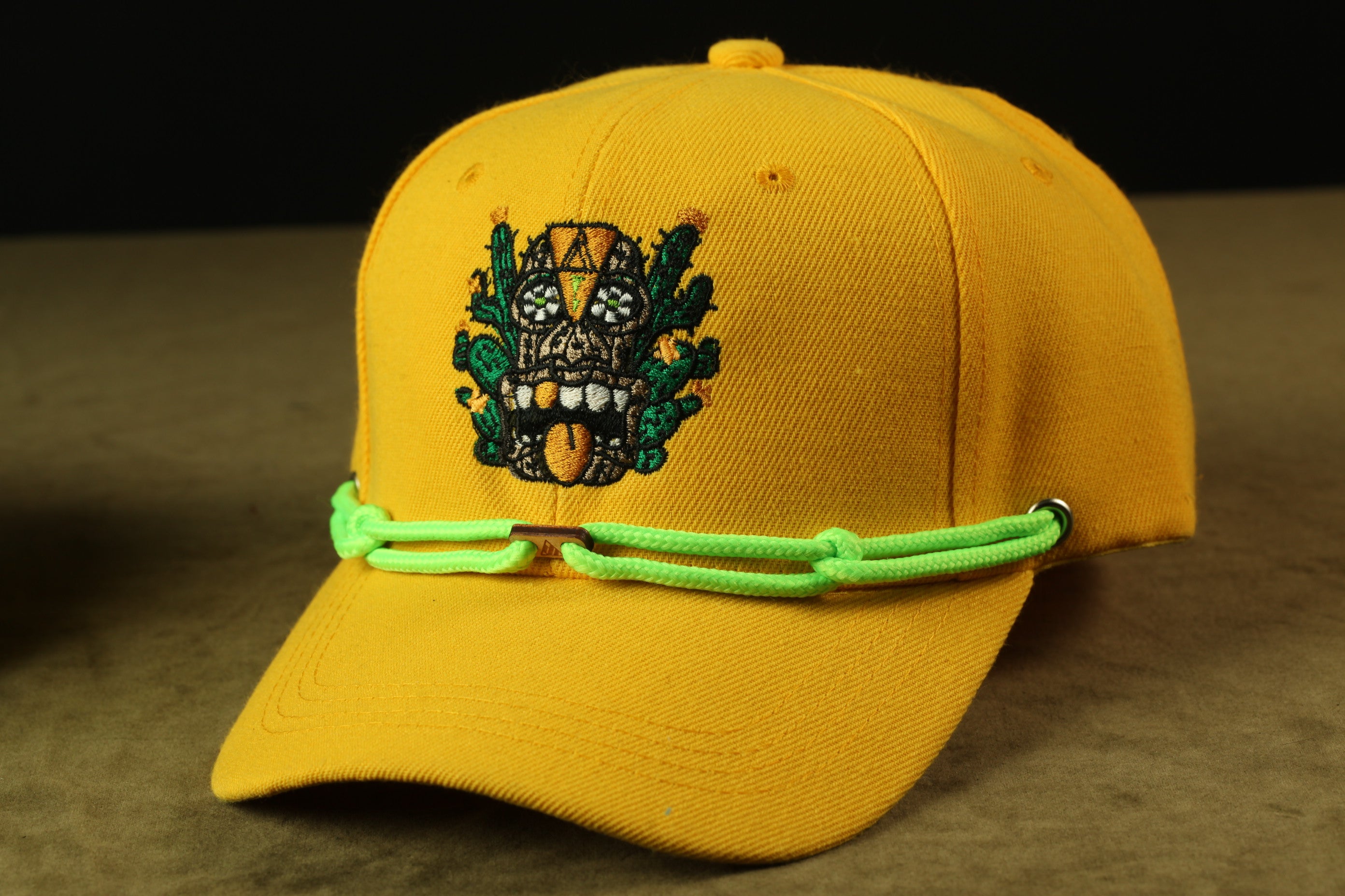 A yellow baseball cap with a colorful, embroidered design on the front.