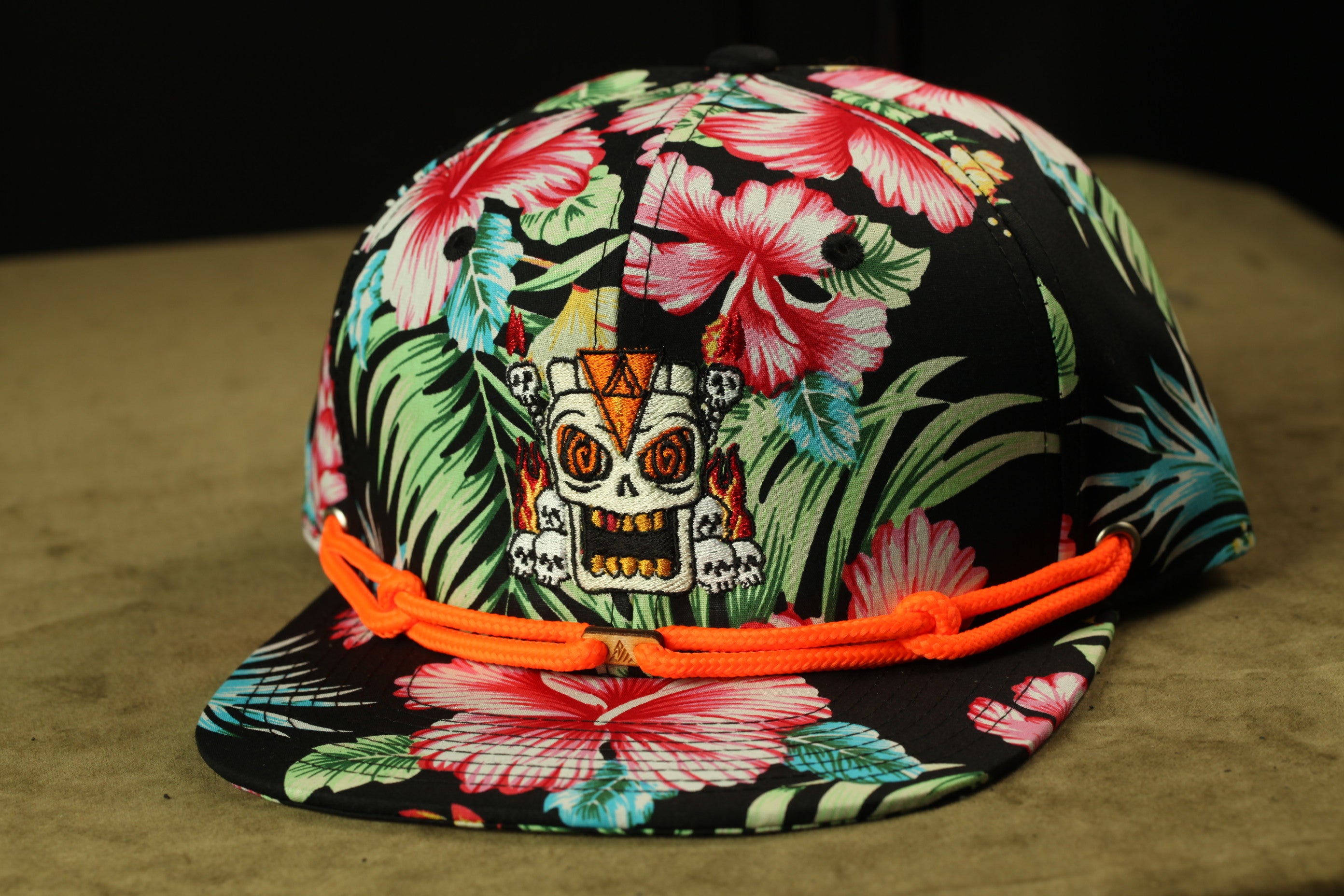 A colorful floral baseball cap with a skull design on the front.