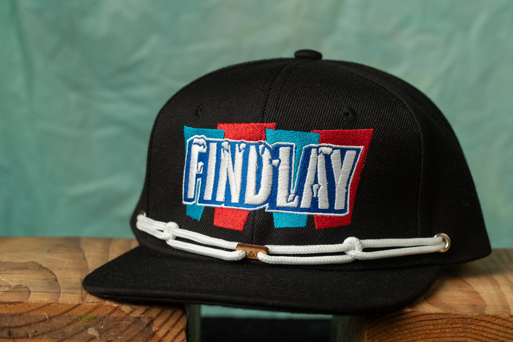 A black baseball cap with a colorful embroidered logo on it.