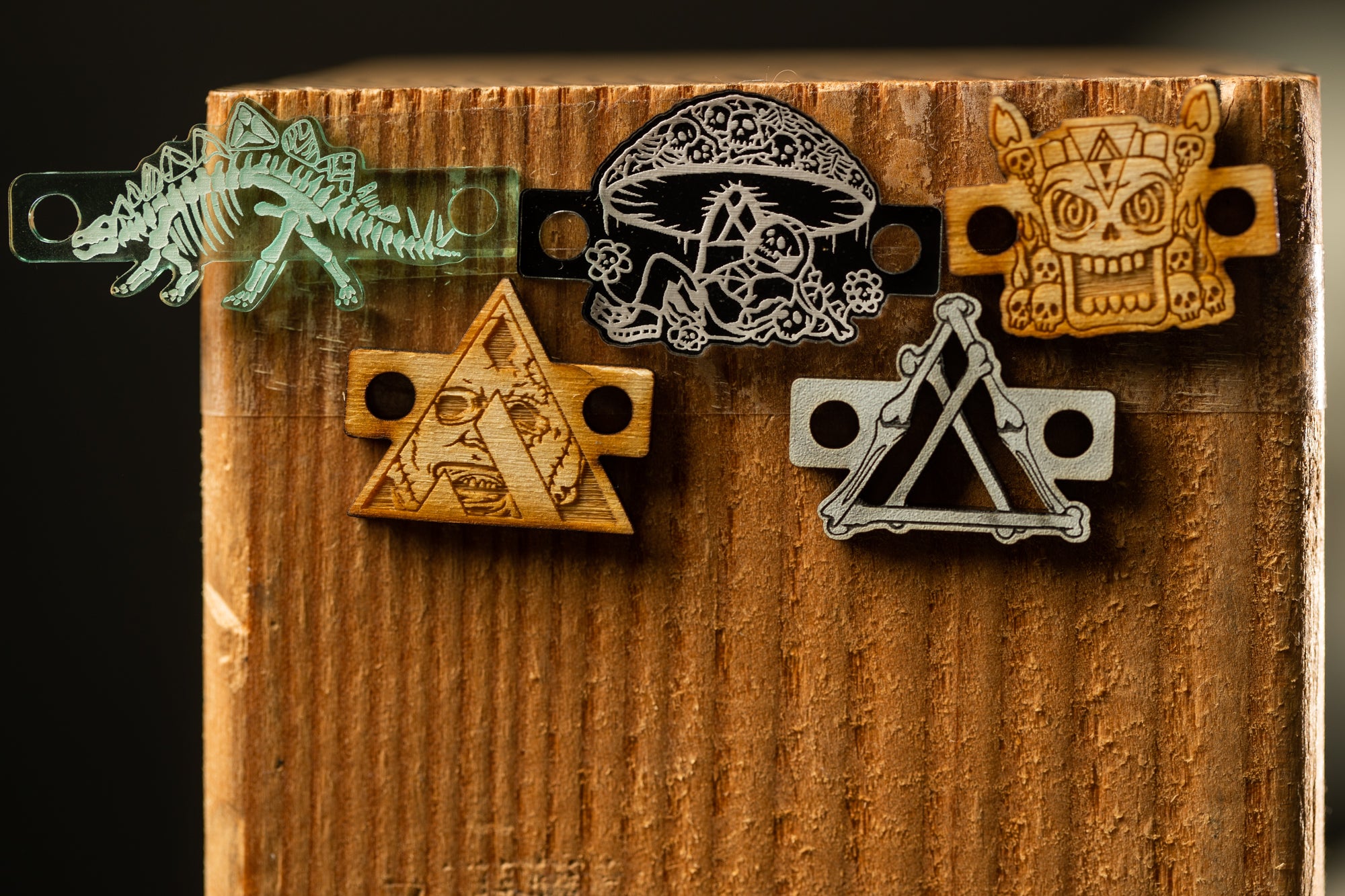 a wooden surface with various wooden objects, including a skeleton, a mushroom, a triangle, and a skull, as well as some other objects that appear to be made of wood.