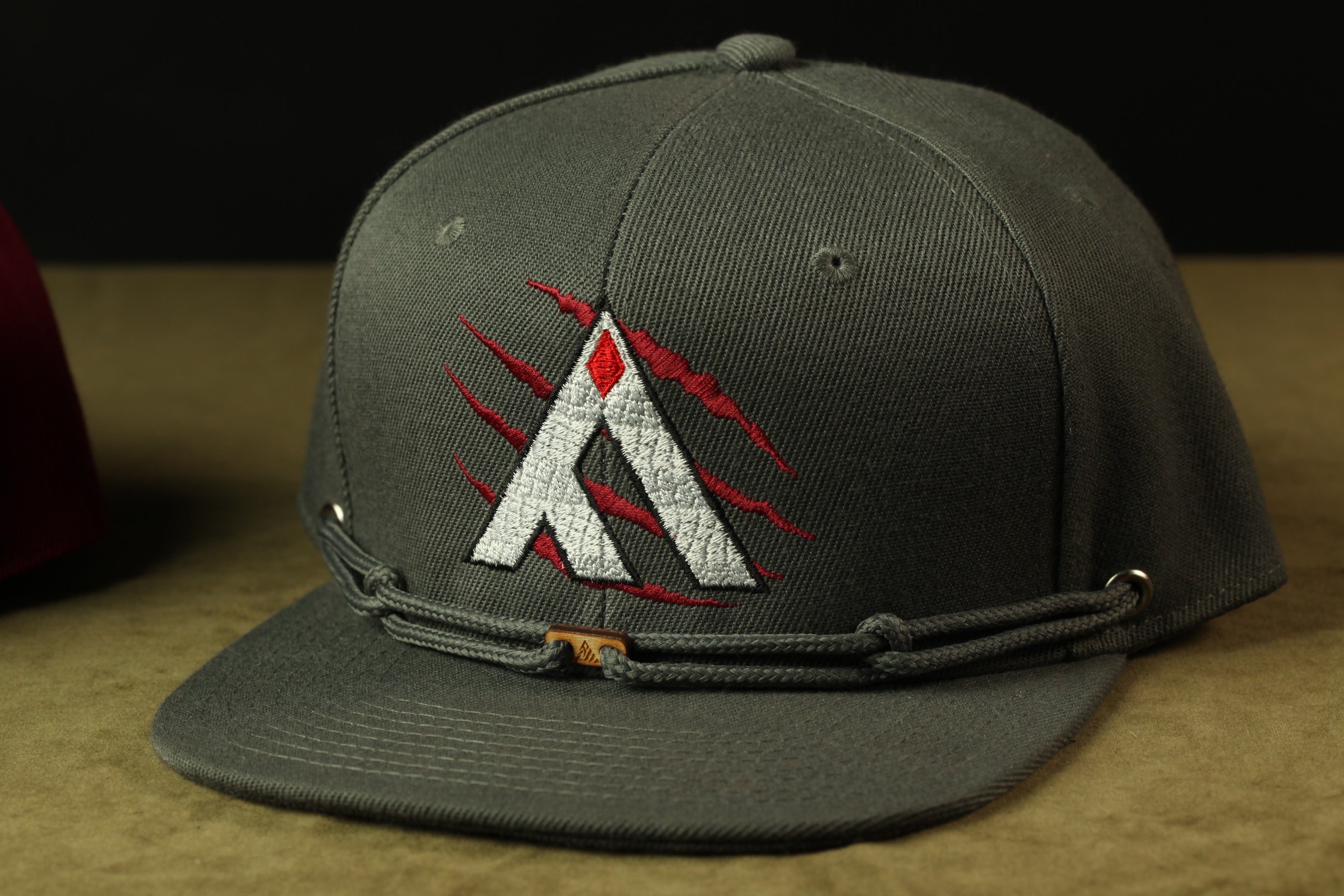 A gray baseball cap with a red and white logo on the front.