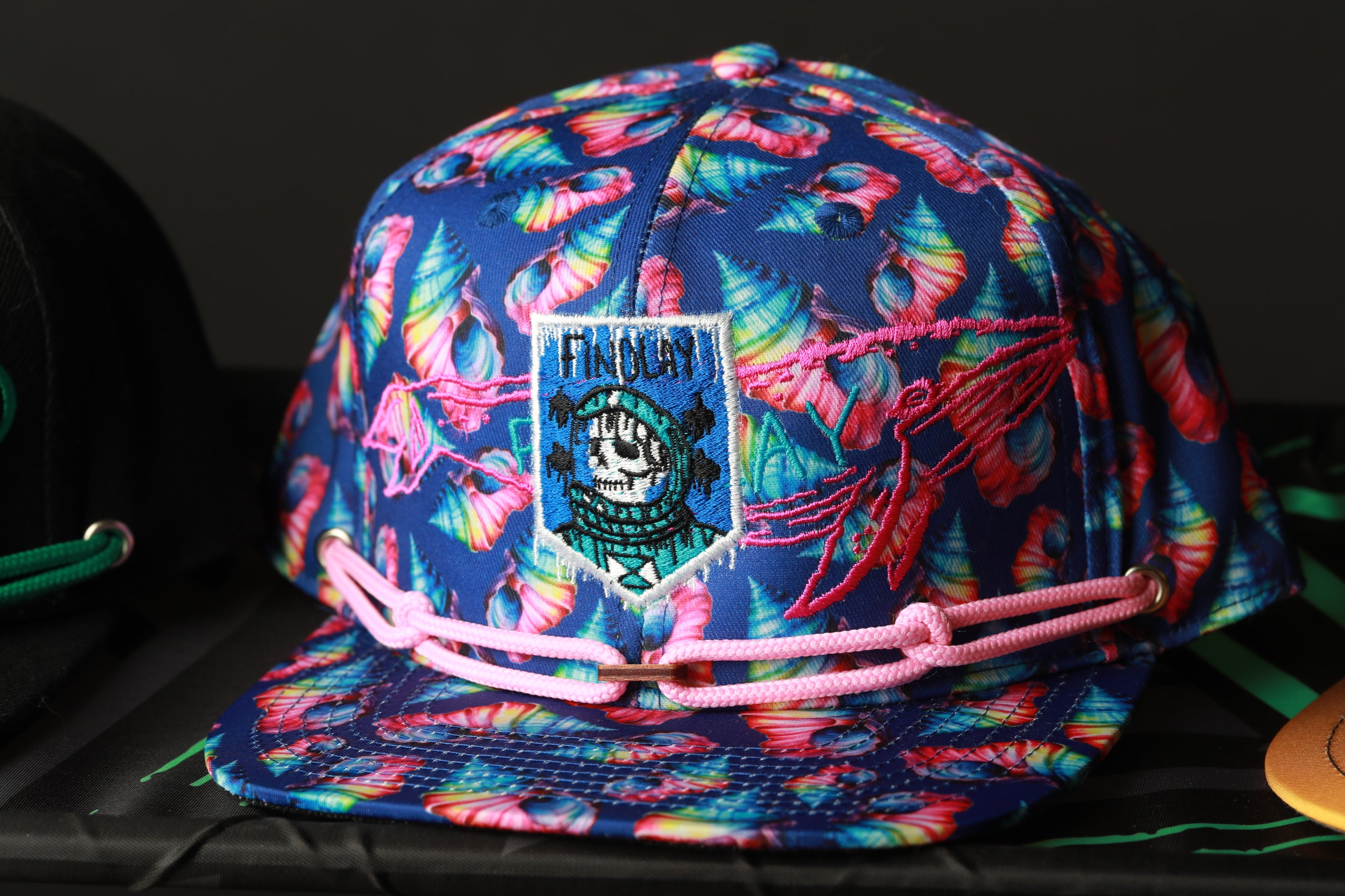 A colorful, patterned baseball cap with a floral design and a patch on the front.