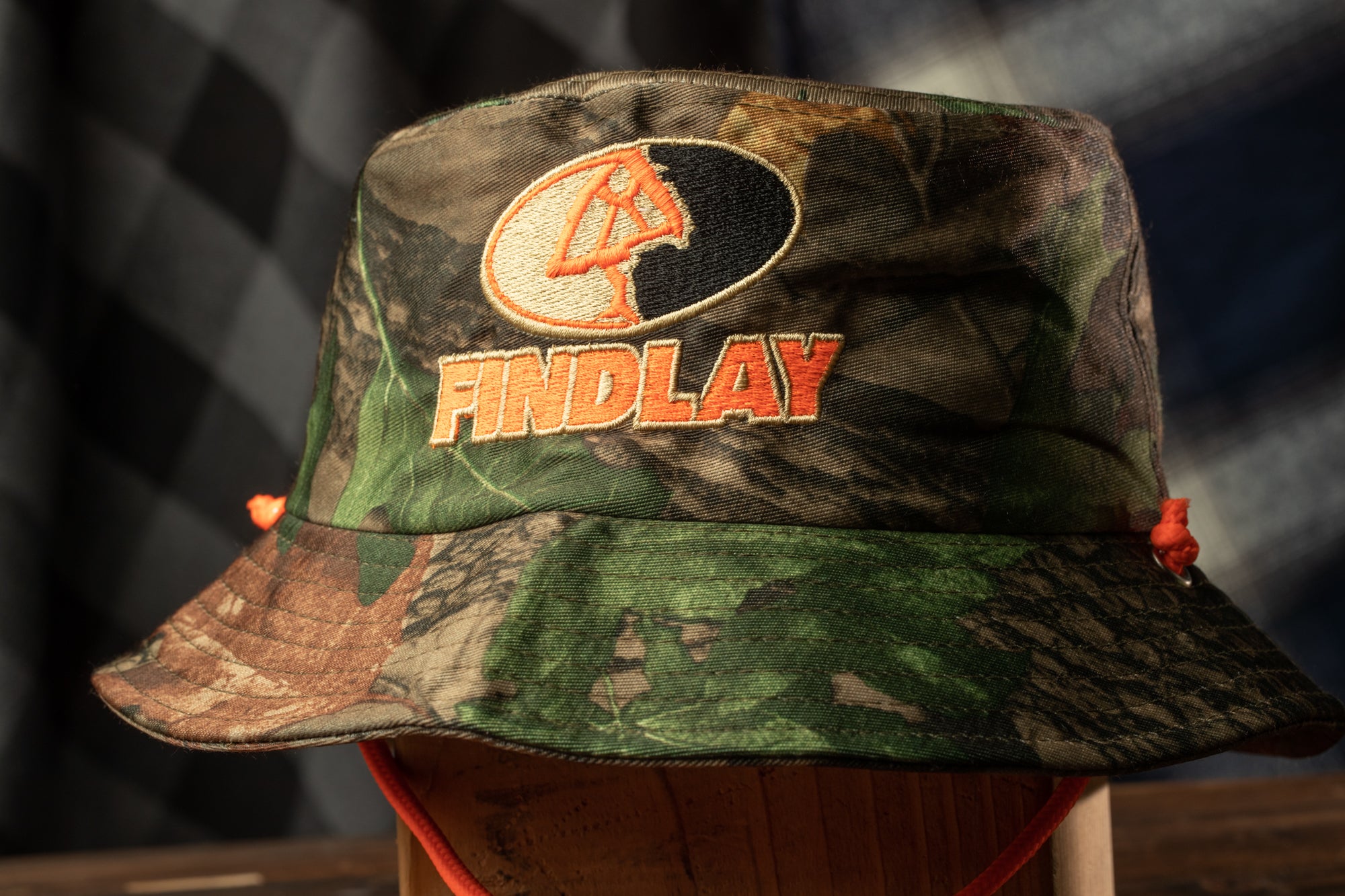 A camouflage bucket hat with the word "FINDlay" printed on it.