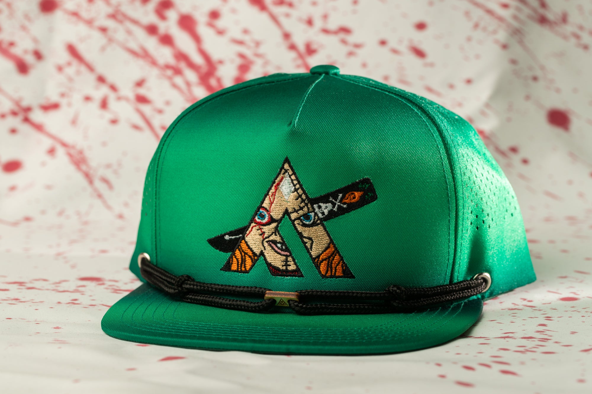 A green baseball cap with a black strap and a unique embroidered logo on the front.