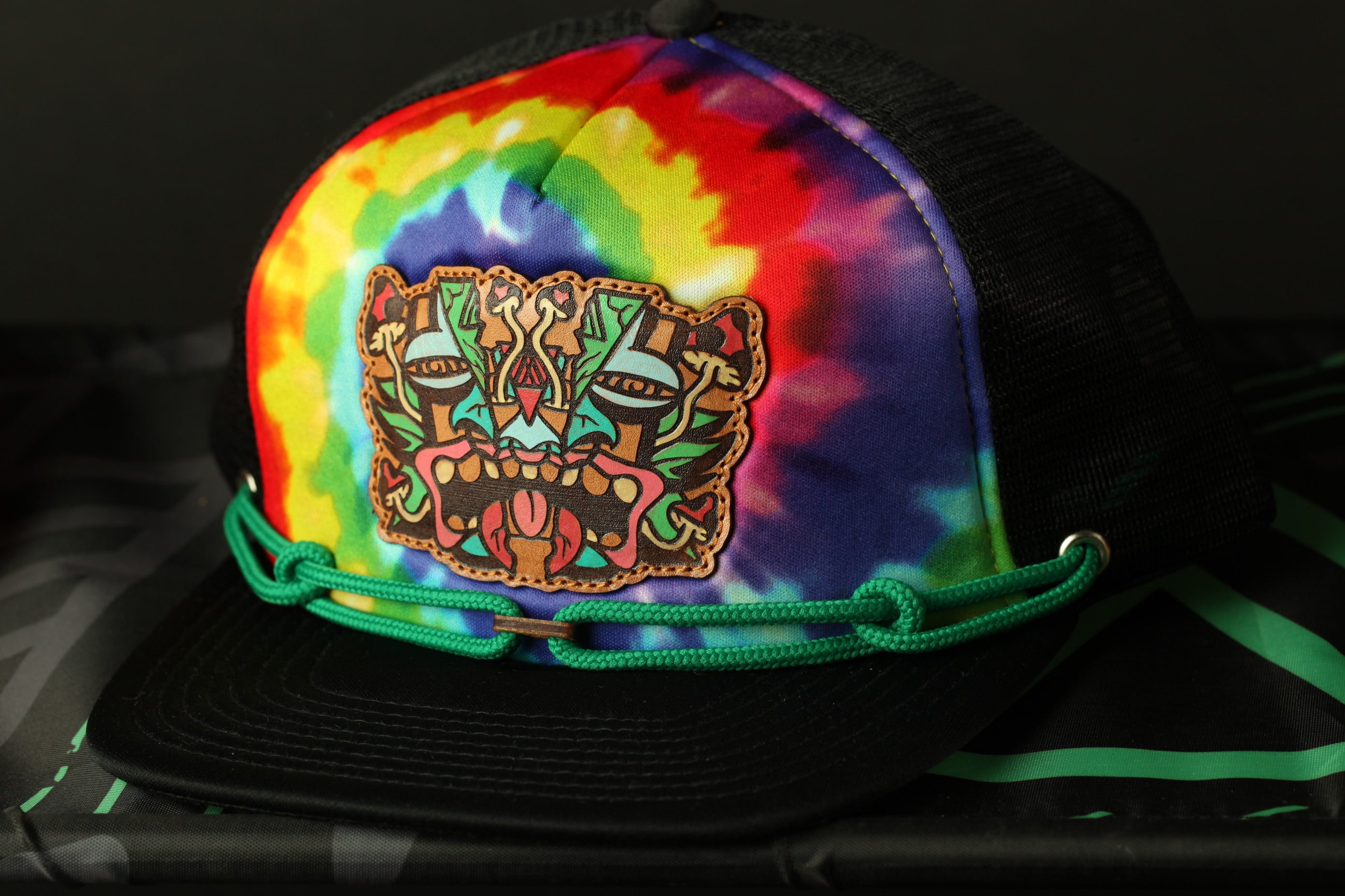 A colorful, tie-dye baseball cap with a unique, abstract design on the front.