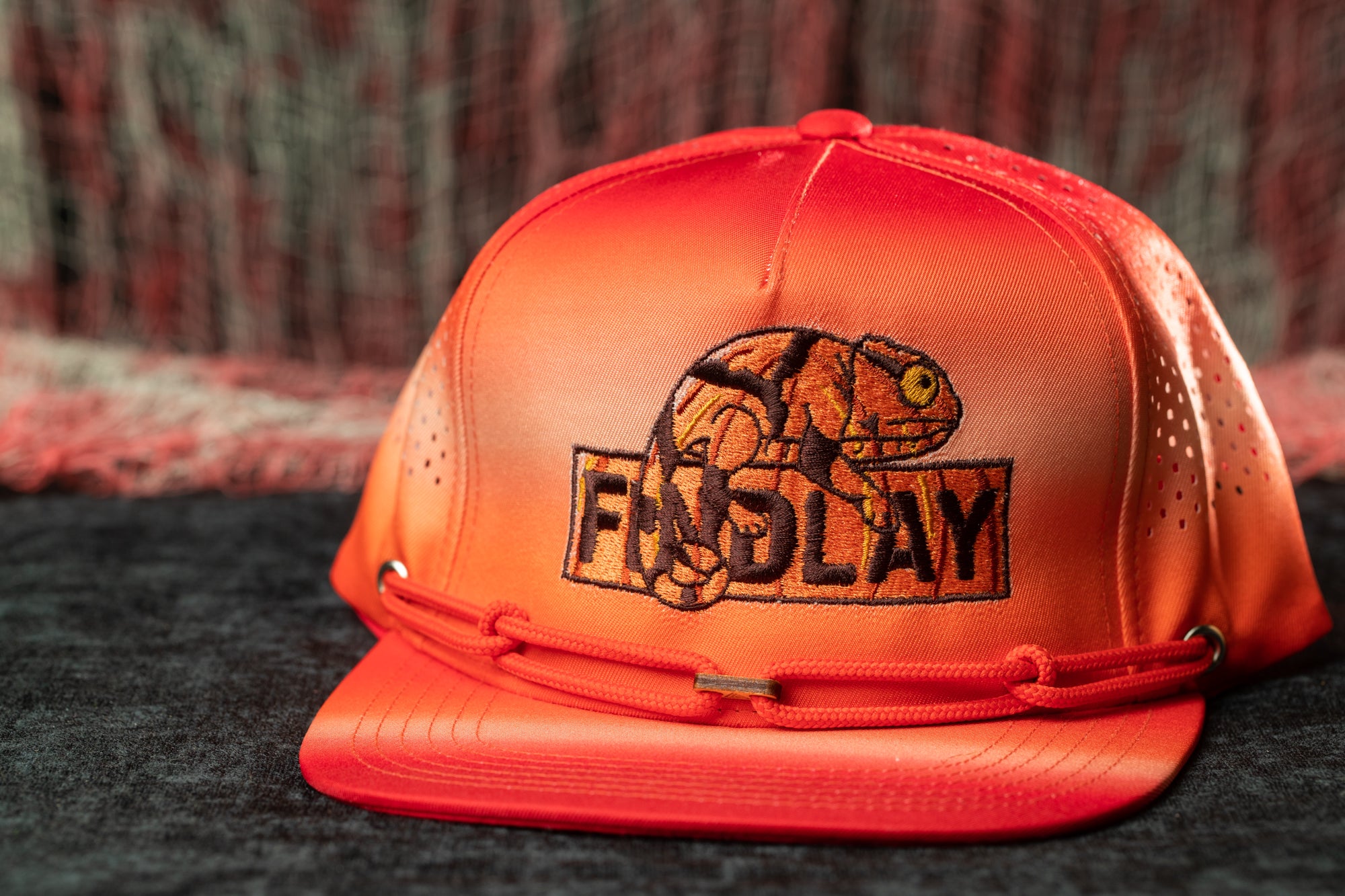 A red baseball cap with an embroidered logo on it.