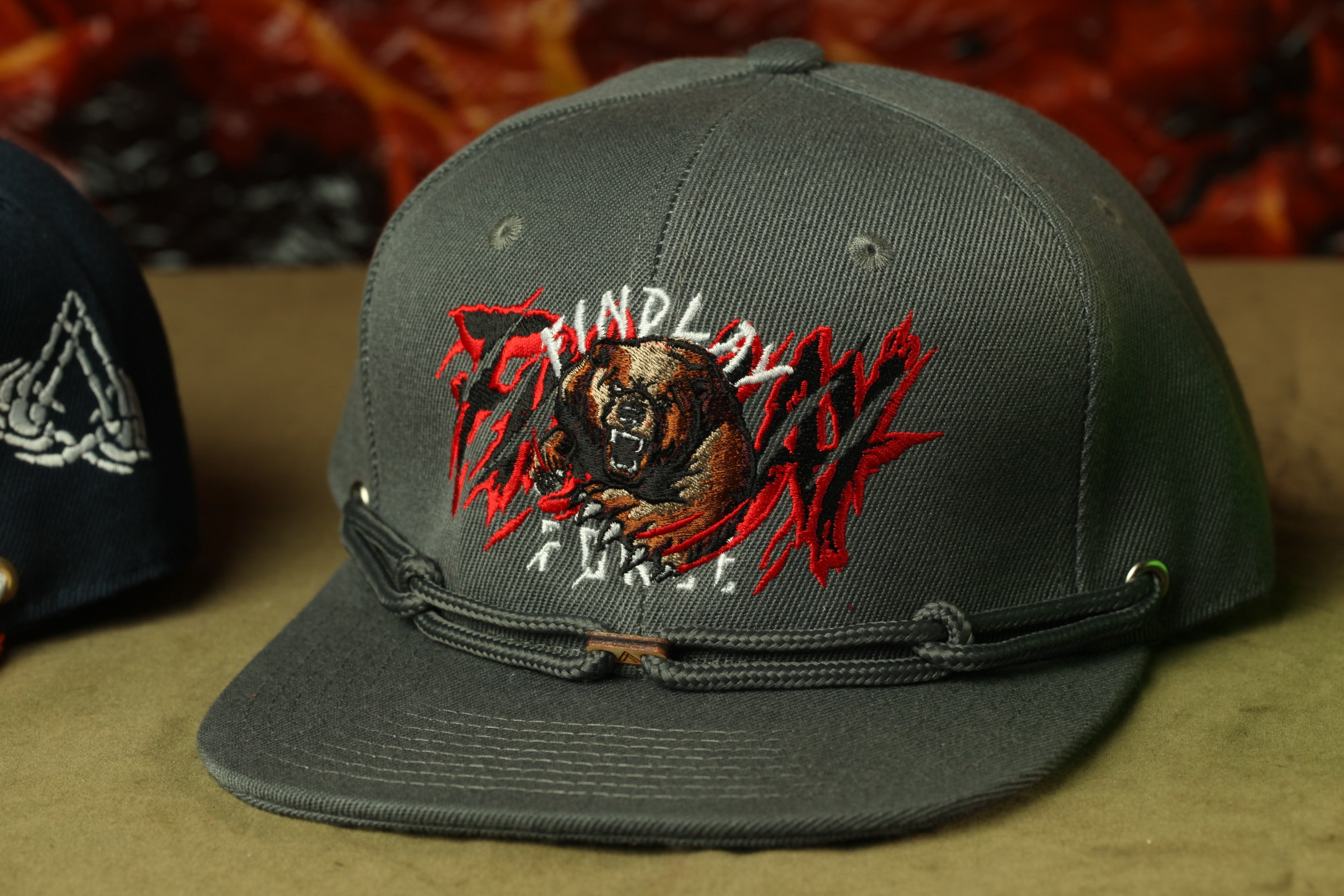 A gray baseball cap with a graphic design featuring a fierce-looking bear.