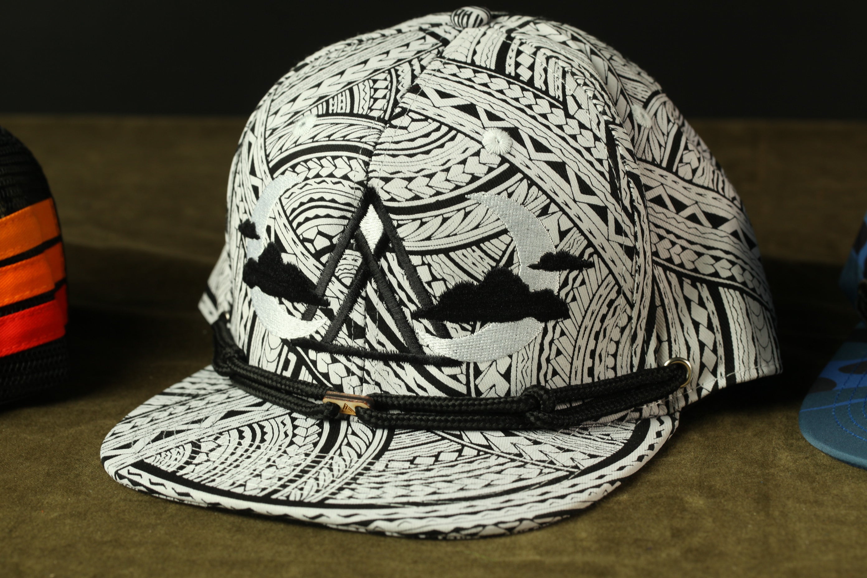 A close-up image of a black and white patterned baseball cap with a distinctive design on the front.