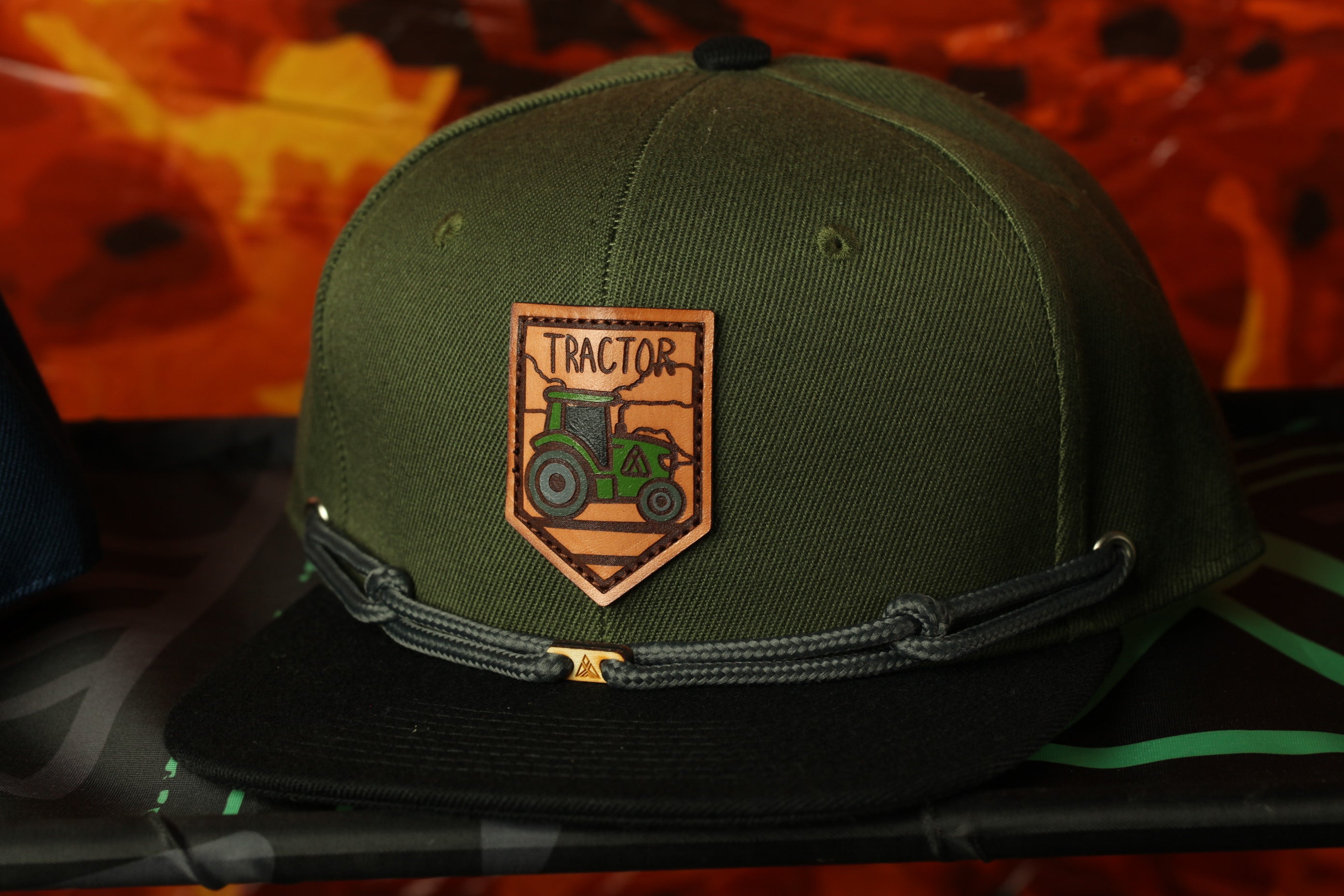 A green baseball cap with a tractor patch on it.