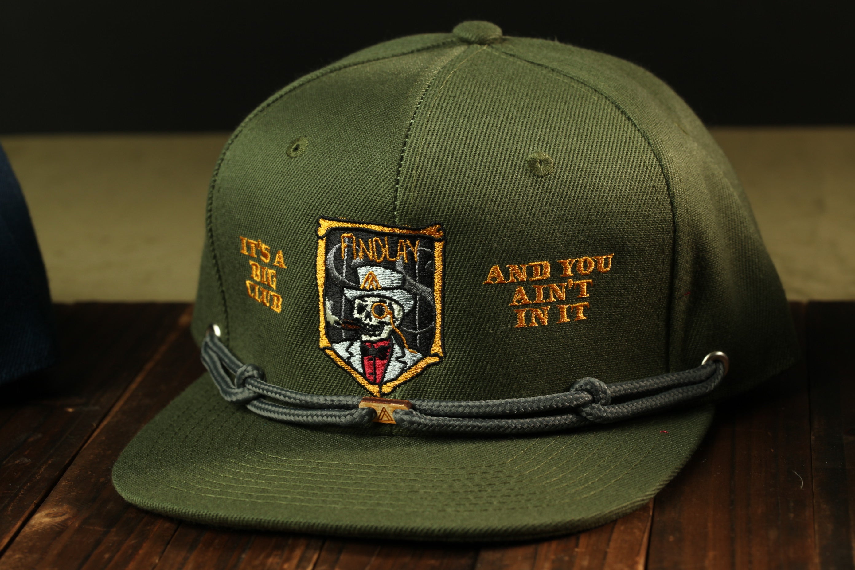 A green baseball cap with a skull and crossbones design, and text on the front.