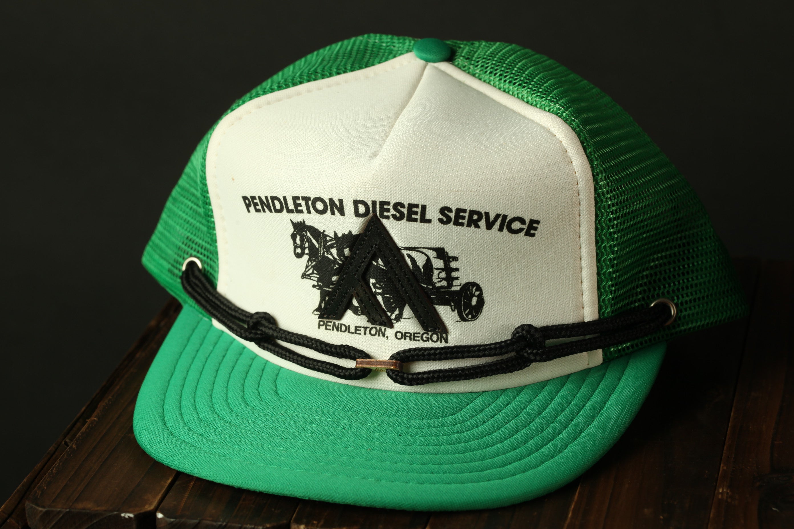 A green and white baseball cap with the text "PENDLETON DIESEL SERVICE" printed on it.