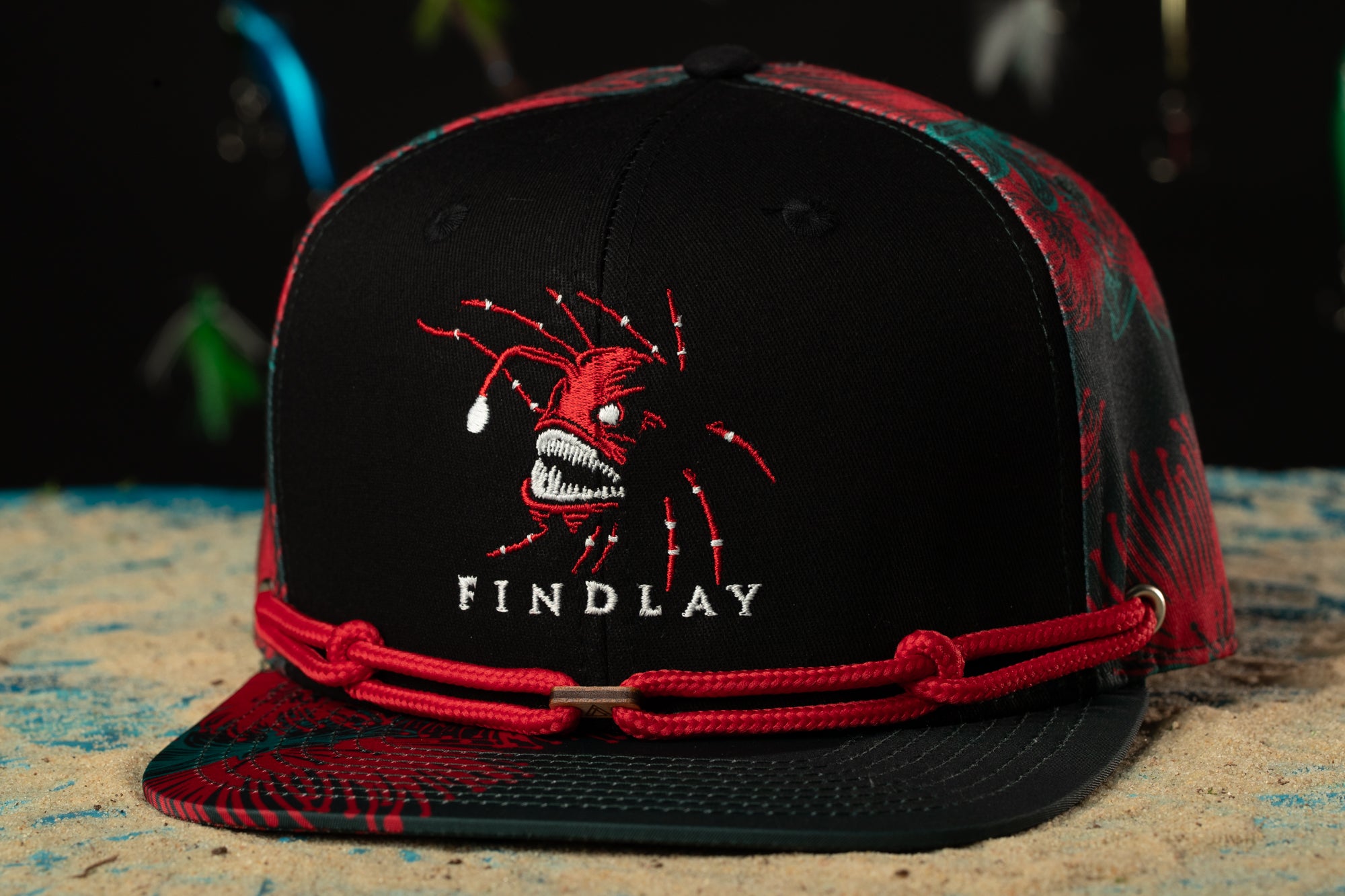 a black and red hat with a spider on it