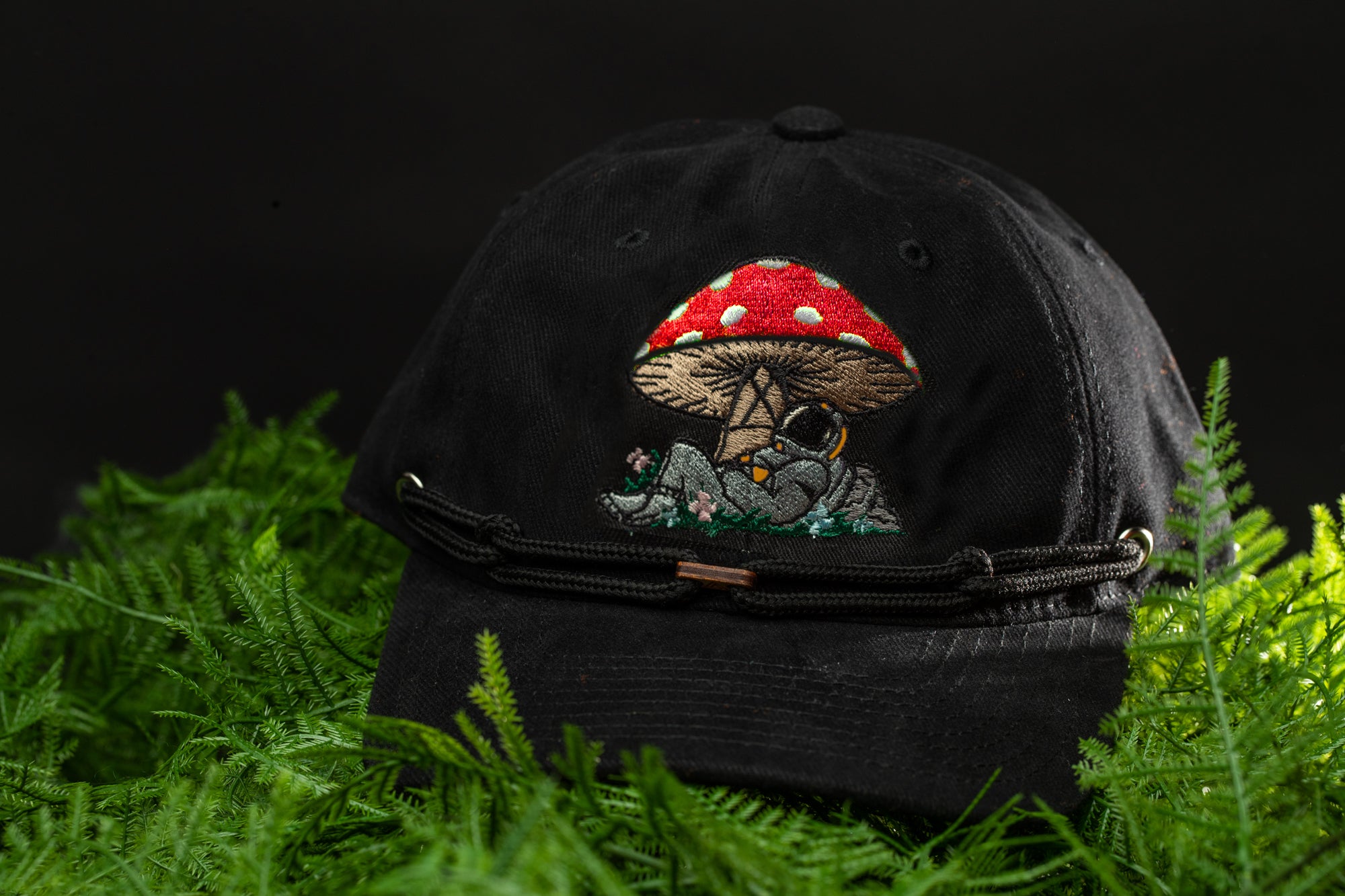 a black hat with a red mushroom embroidered on it